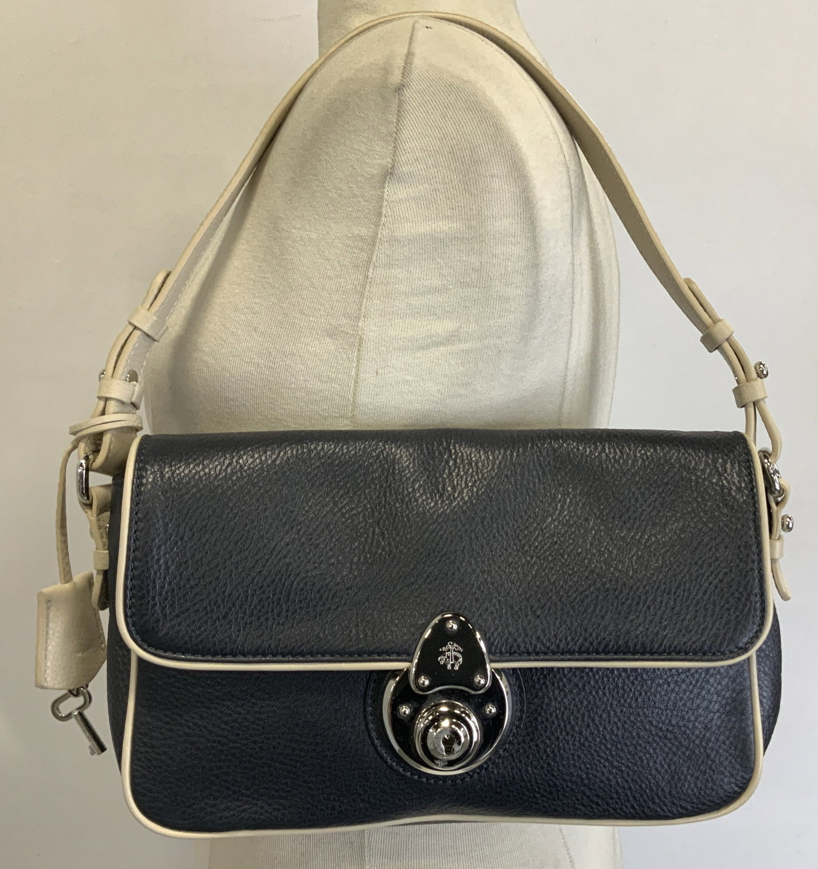 Brooks Brothers Navy & Tan Flap Shoulder Bag: Shoulder bag is navy & tan toned. Features a silver-toned metal clasp with a keyhole and a small emblem. Flap closure & adjustable straps. Comes with silver toned key. Lock appears to be stuck. Signed