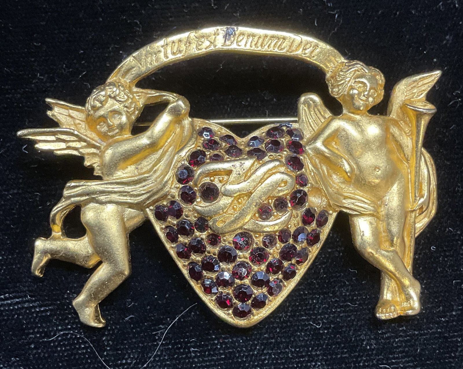 Karl Lagerfeld Gold Pl Cherub Heart Brooch: Karl Lagerfeld gold plated Virtufest Denum Dei brooch with cherub and heart motif and red crystal decoration. Signed. Measures approx 1.5 x 2.5 inches. Some scratching. Jewelry, estate jewelry, costum