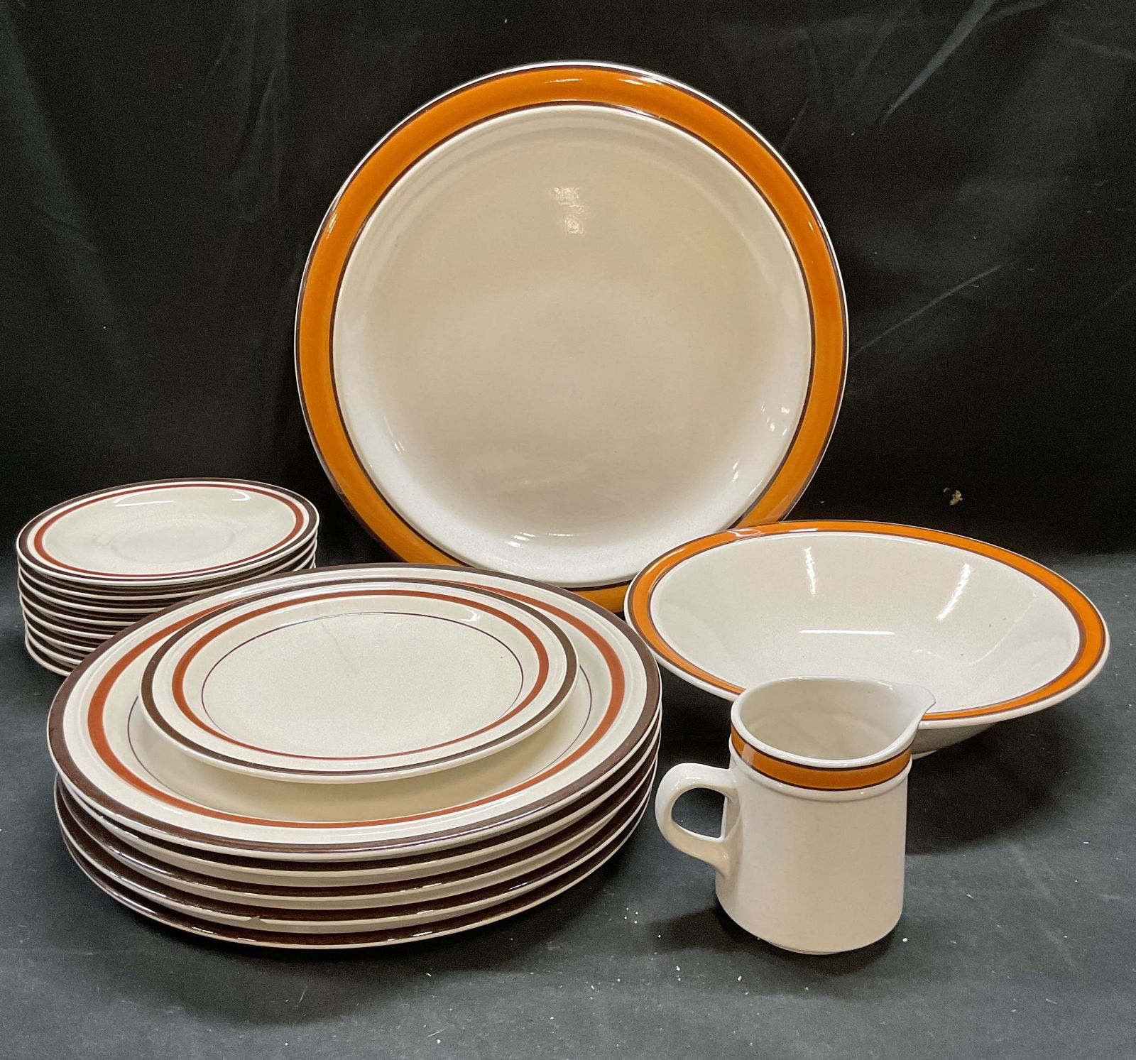 Set 17 Color Stone Orange Sienna Tableware: Set of 17 pieces Color Stone tableware in Orange pattern and Stone Ware tableware in Sienna pattern. Signed. Made in Japan. Includes 1 Orange platter or serving dish, 5 Sienna dinner plates, 1 Sienna