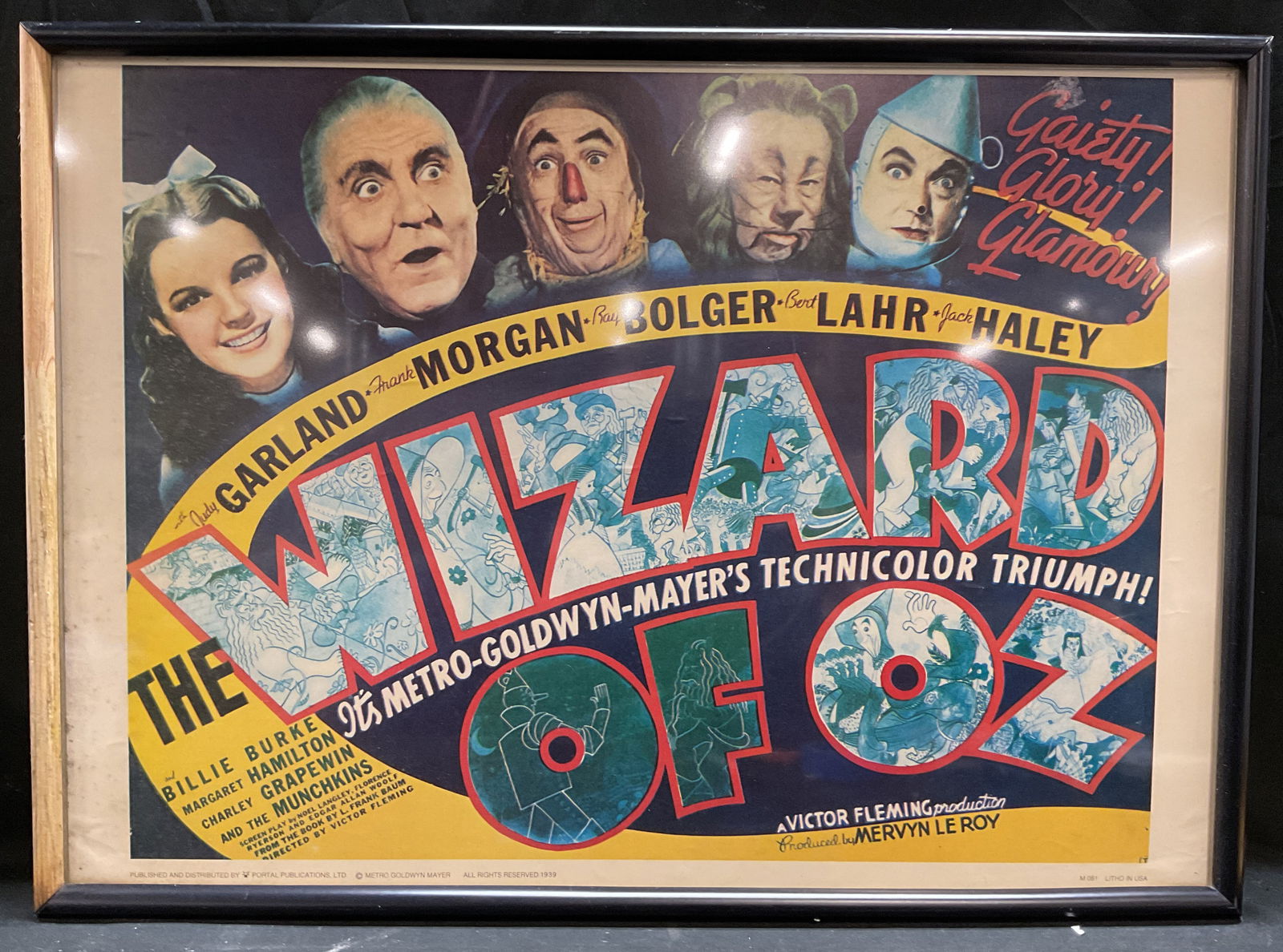 Frmd The Wizard of Oz 1939 Repro Litho Poster 29in: Framed lithograph poster on paper. Reproduction print of 1939 theatrical poster for The Wizard of Oz. Copyright Metro Goldwyn Mayer. Published by Portal Publications, date unknown. Black wood frame. N