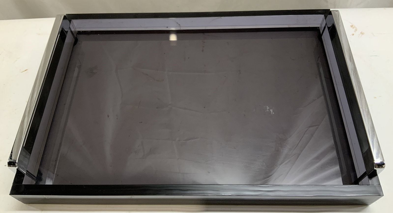 Smoked Black Acrylic Tray with Silver Mtl Handles: Tray appears to be acrylic & features dual silver-toned metal handles. Tray is smoked black toned. Surface wear consistent to age, use & exposure. Measurements: length 15.5in x width 11in x height 2.3