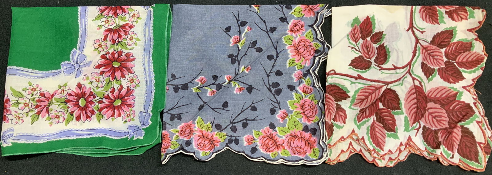 Lot 3 Vntg Assorted Floral & Leaf Handkerchiefs: Handkerchiefs appear to be cotton material. Feature floral & leaf patterns in shades of red, pink, green & white. 2 handkerchiefs feature scalloped edges. No visible signatures or markings. Surface we