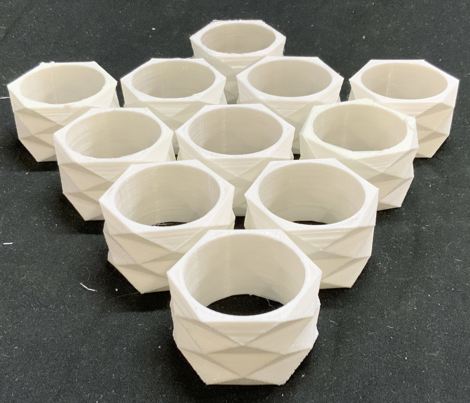 Set 11 Geometric Form Napkin Rings White: Lot includes 11 napkin rings. Each are white toned and plastic. Napkin rings each have 3 dimensional geometric forms. Each ring measures approximately 1.75 inches wide 1 inch deep. Napkin rings, white
