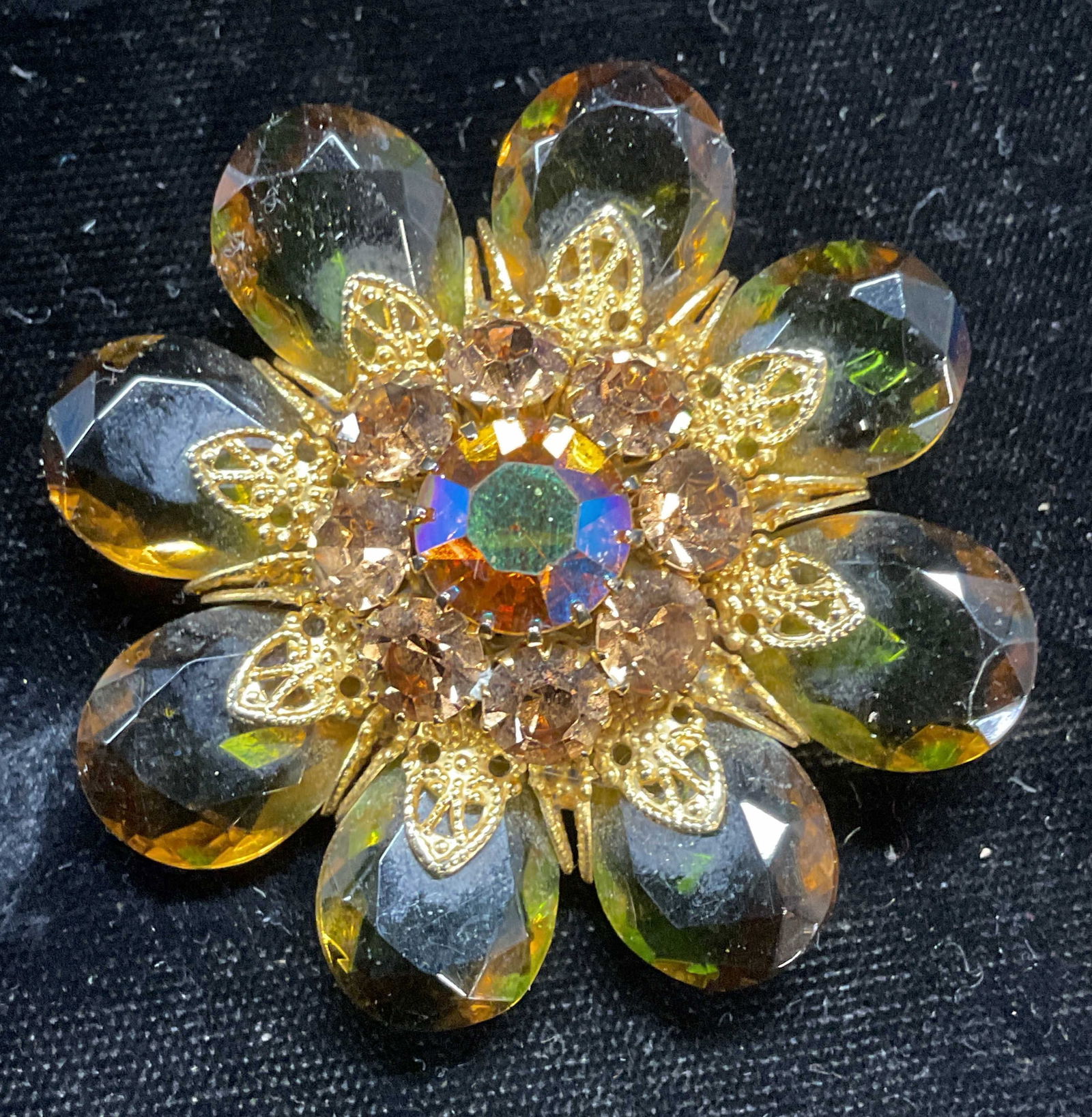 Gold Tone Amber Crystal Flower Brooch: Vintage gold tone filigree amber and green toned crystal flower brooch. Measures approx 2 inches wide. Some scratching. Jewelry, estate jewelry, costume jewelry, cocktail jewelry, fashion jewelry, acc