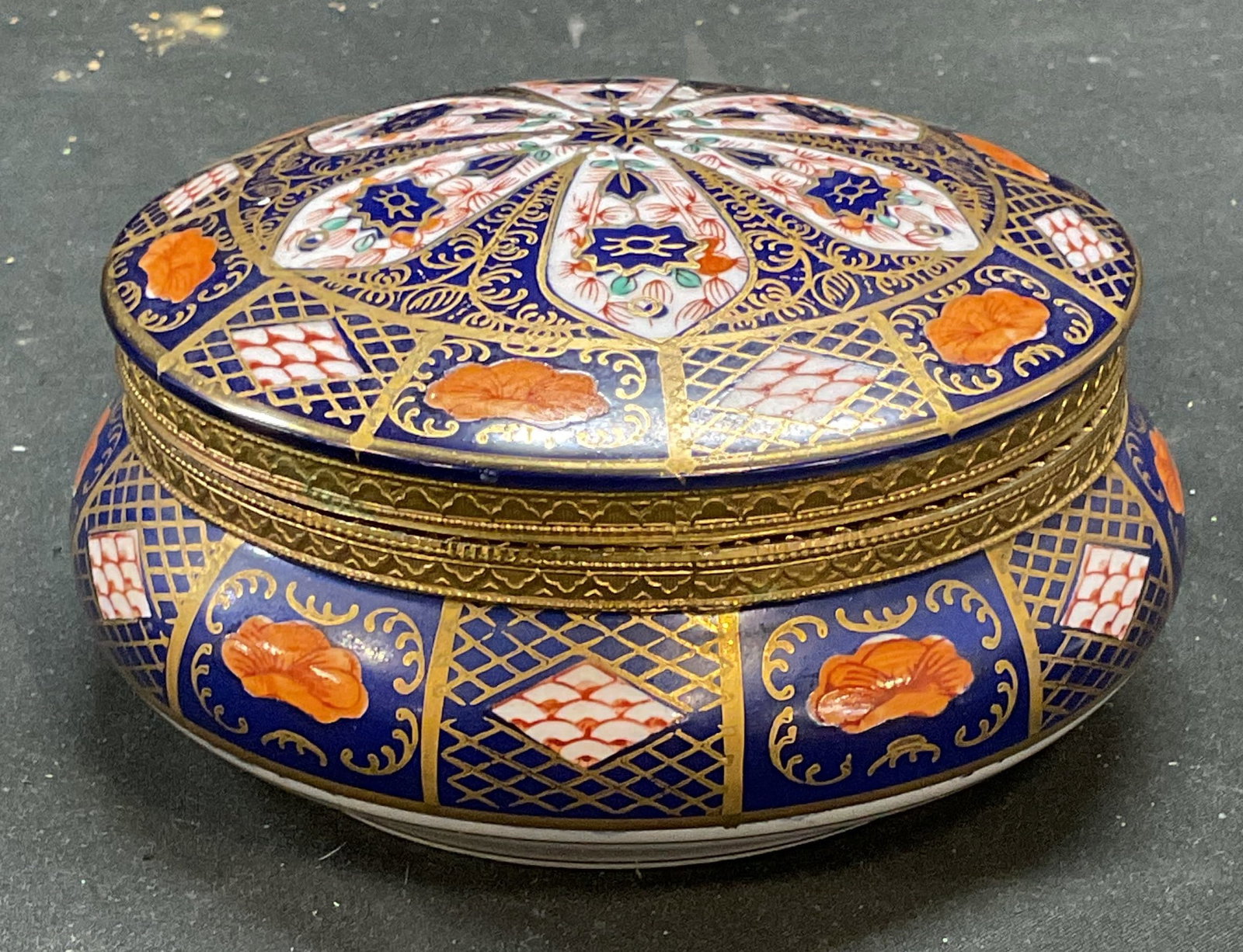 Vtg Signed Gilt Imari Porcelain Lidded Bowl: Vintage signed porcelain bowl with hinged lid. Imari pattern, hand painted blue and red with intricate floral designs. Gilt decoration. Signed with crossed arrows hallmark. Measures approx 5.5 x 2.75 