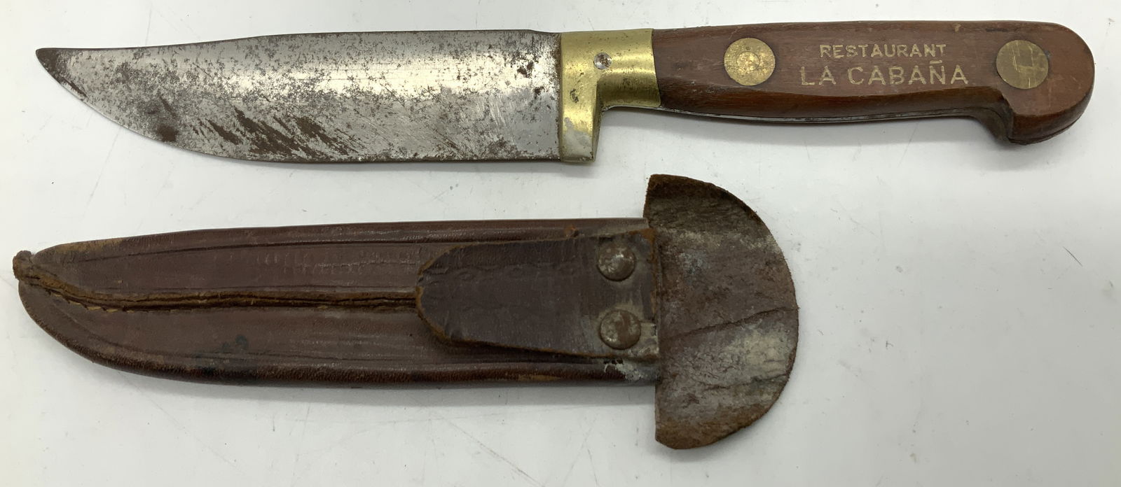 Vntg Restaurant La Cabana Knife & Leather Sheath: Vntg Restaurant La Cabana Knife & Leather Sheathe Knife appears to be stainless steel & a wooden handle. Handle reads, RESTAURANT LA CABANA. Knife comes with leather sheath. Surface wear consistent to