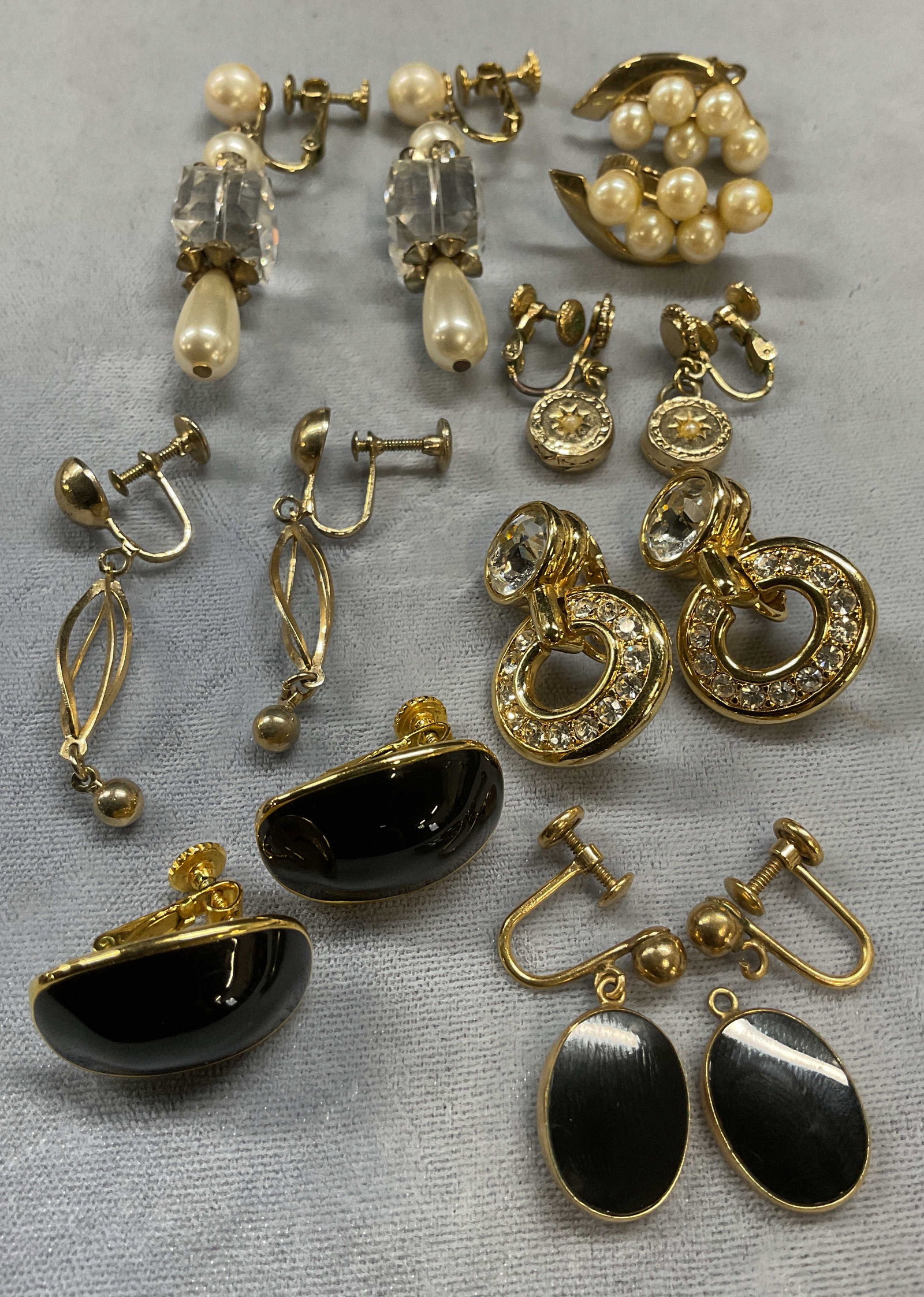 Lot 7 Vtg Napier Gold Tone Earrings +: Lot of 7 pairs of vintage gold tone earrings. Signed Napier black enamel earrings, faux pearl earrings, crystal earrings, and dangle earrings. Largest approx 2 inches long. One pair needs repair. Some