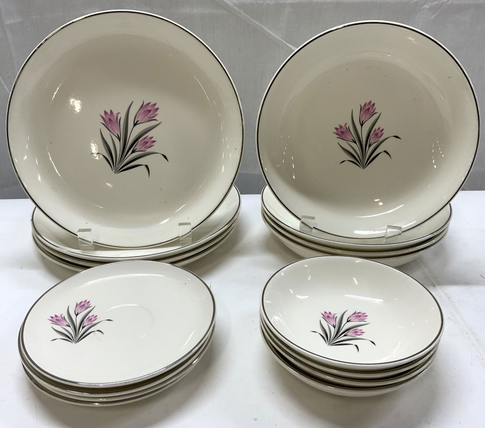 16 Pink Crocus Pattern Porcelain Tableware: 16 Pink Crocus Pattern Porcelain Tableware 4 small bowls, 4 saucer plates, 4 big bowls & 4 dinner plates. Each piece has pink circus flowers with black leaves. Pieces have a platinum trim. Surface wea