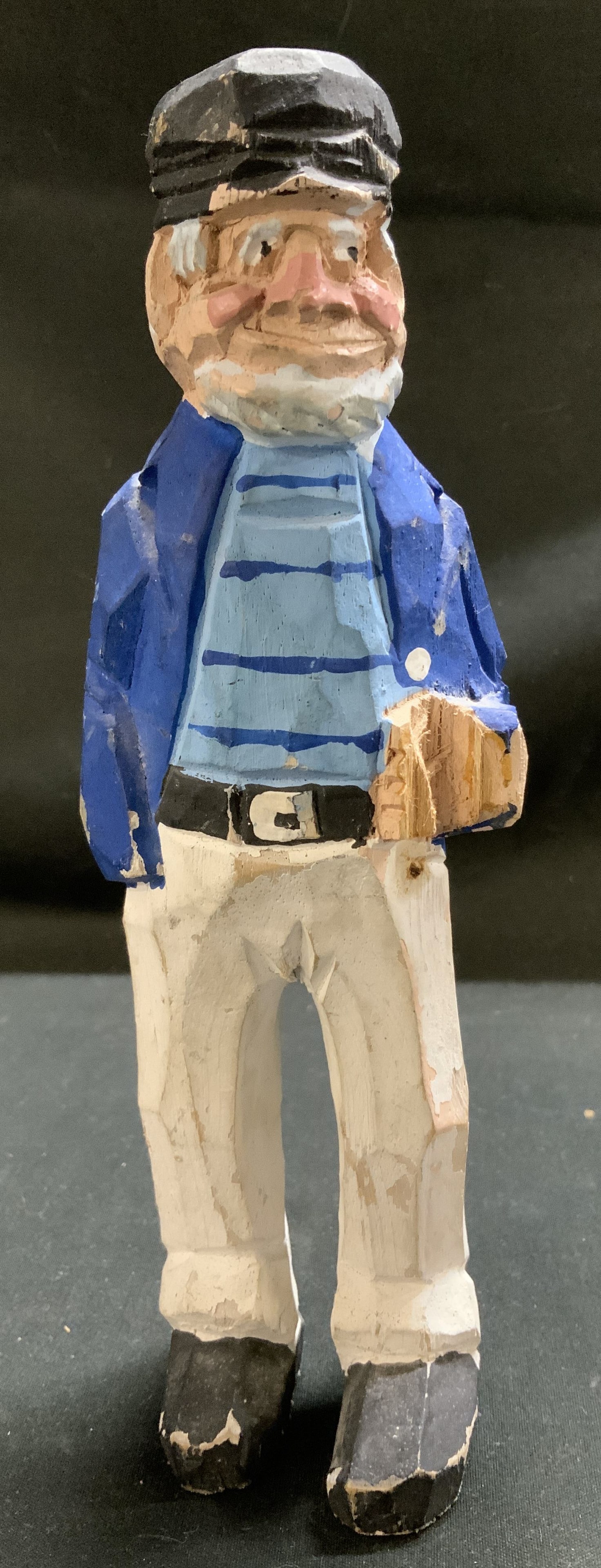 Vntg Hand Carved Wooden Sailor Figurine: Figurine is hand-carved & hand-painted. Depicts a sailor wearing a traditional captain outfit, including a cap, a striped shirt, a blue jacket, and white pants. Appears to be missing piece. Surface we