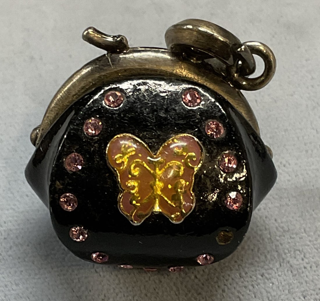 Anna Sui Black Enamel Crystal Purse Pendant: Anna Sui black enamel pink crystal butterfly motif purse form charm pendant. Signed. Measures approx 1 x 1 inches. Some scratching. Crystals need replacement. Jewelry, estate jewelry, costume jewelry,