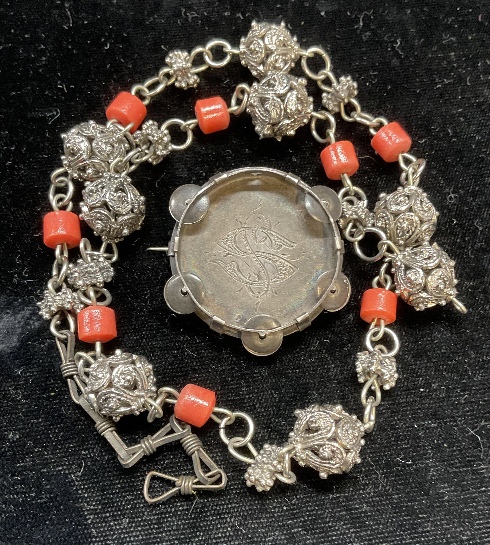 Lot 2 Engraved Silver Brooch +: Lot of 2 jewelry pieces. Vintage engraved monogram silver brooch. Tests for silver, purity unknown. Measures approx 1.25 inches wide. Total weight .34 ozt. Silver tone and faux coral beaded necklace. 