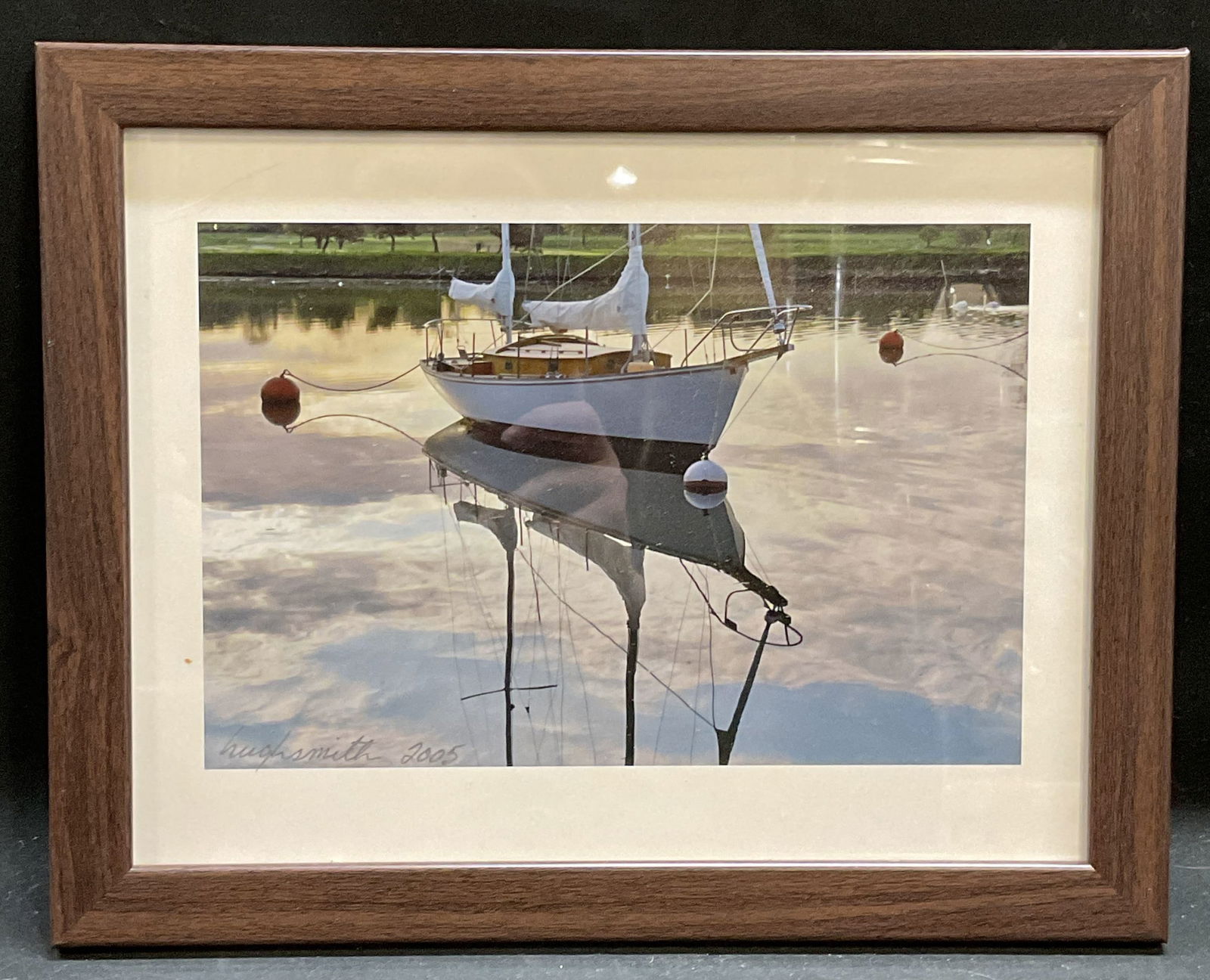 Framed Signed Hugh Smith Sailboat Photograph: Framed photograph on paper. Signed and dated lower left, Hugh Smith 2005. View of sailboat on water. Wood frame. Not examined out of frame. Frame measures approx 9.5 x 12 inches. Some wear consistent