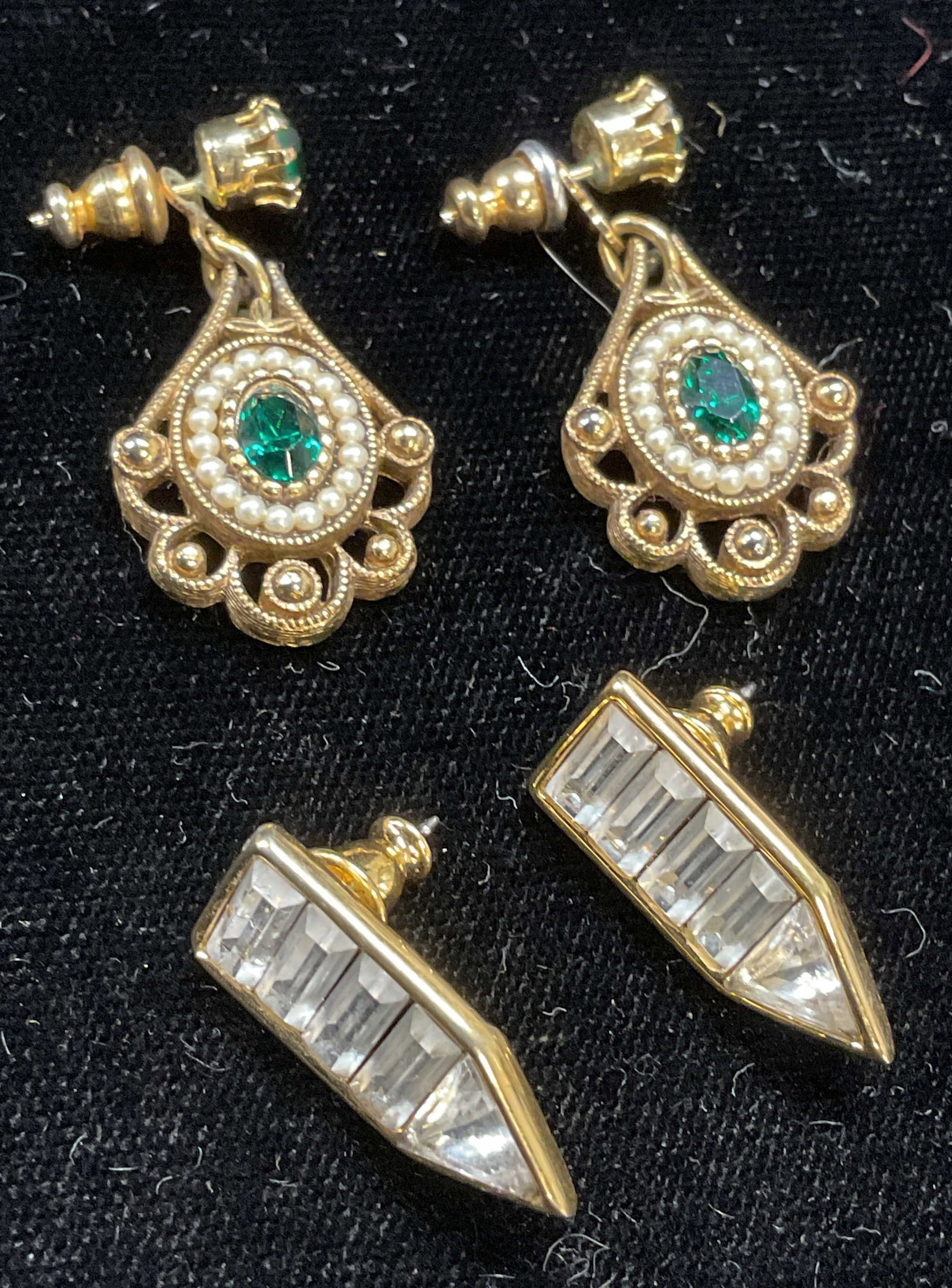Lot 2 Vtg Avon & Monet Crystal Earrings: Lot of 2 pieces. Avon gold tone green crystal and faux pearl earrings. Monet gold tone and colorless crystal earrings. Both signed. Larger measure approx 1.25 inches long. Some wear including scratchi
