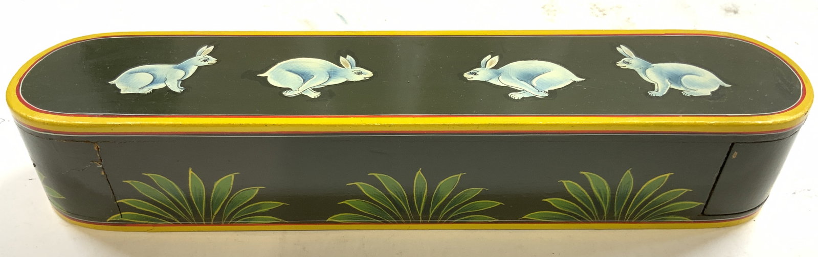 Vintage Wooden Rabbit Pattern Incense Box: Incense box is green with yellow toned detail, rabbit and leaf patterns. One side of box opens. Appears to be wooden. Box has elongated oval form. Measures approximately 11 inches long 2,5 inches deep