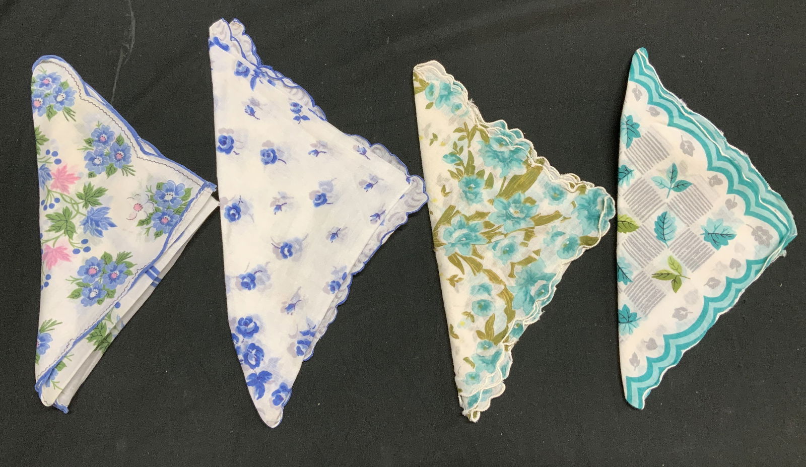 Lot 4 Vntg Assorted Floral Handkerchiefs: Handkerchiefs appear to be cotton material. Feature floral patterns in shades of blue w green leaves. 3 handkerchiefs have scalloped edges. Surface wear consistent to age, use & exposure. Measurements