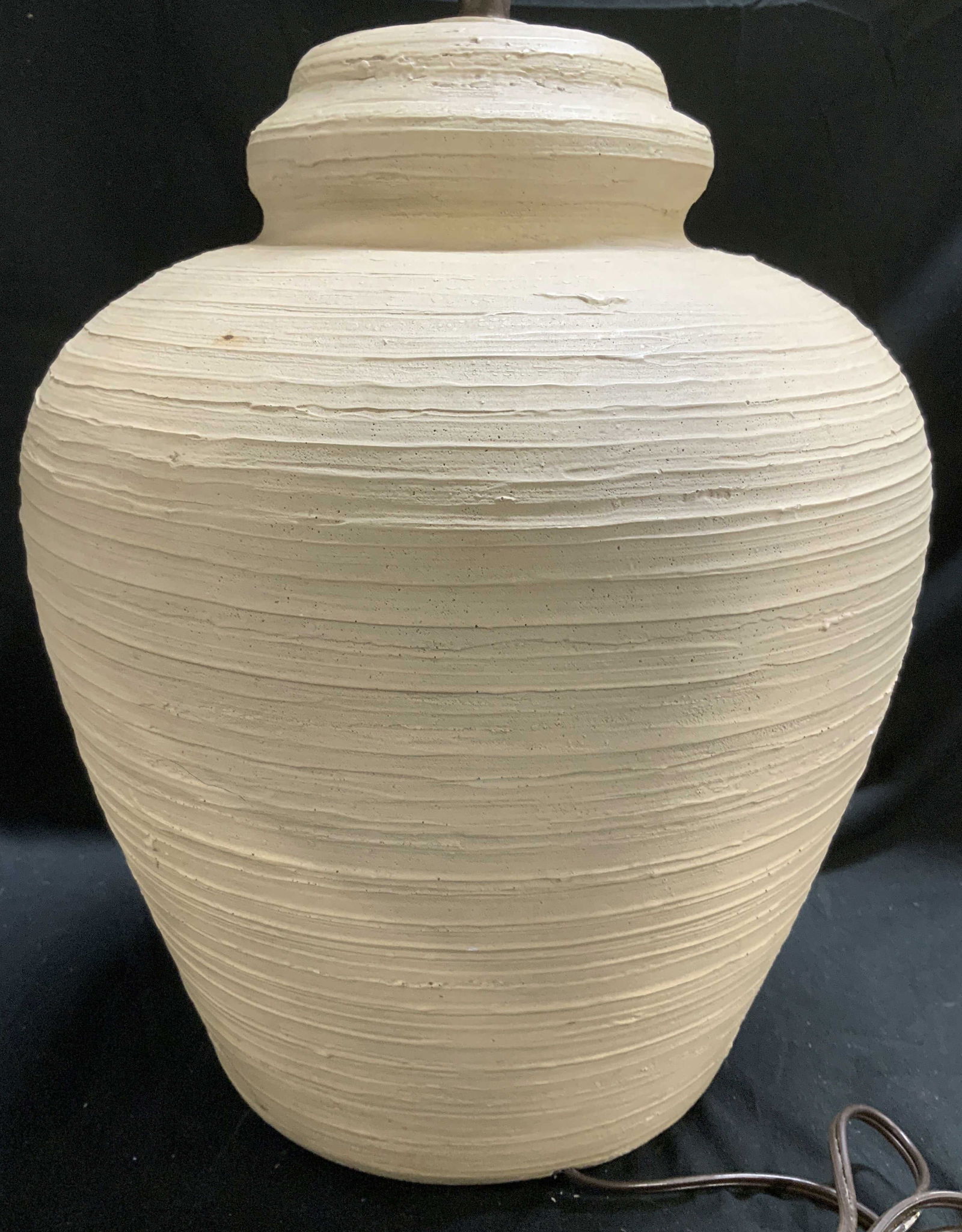 Signed 1975 Textured Ceramic Beehive Table Lamp: Ceramic table lamp featuring a textured ribbed design & beige tone. Appears to be the shape of a beehive. Features a harp w finial. Visible signature, partial readings 1975. Surface wear consistent to