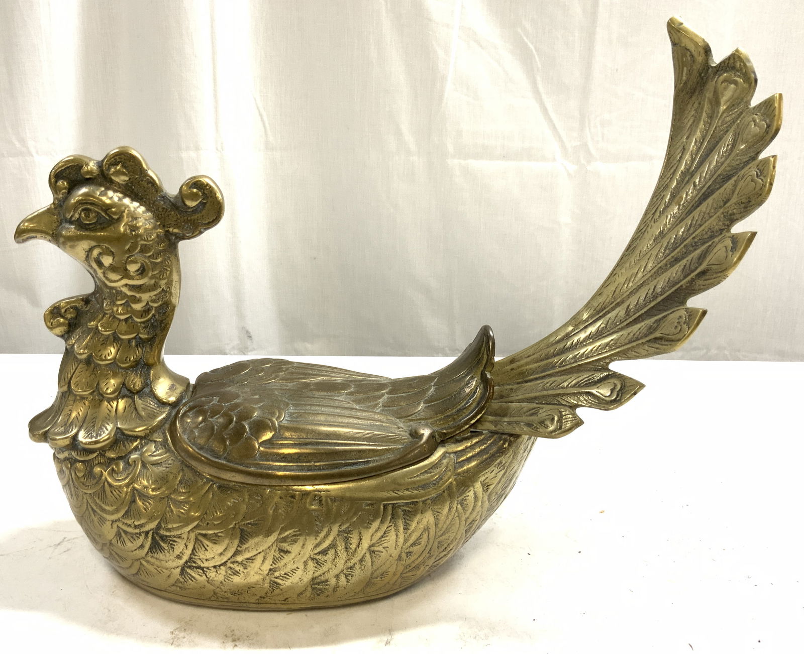 Vntg Asian Brass Pheasant Ornamental Box W Lid: Ornamental box is gold toned and brass. Piece has pheasant form. Box includes lid. Piece has intricate Relief to show facial and feather detail. Asian ornamental pheasant box. Piece measures approxima