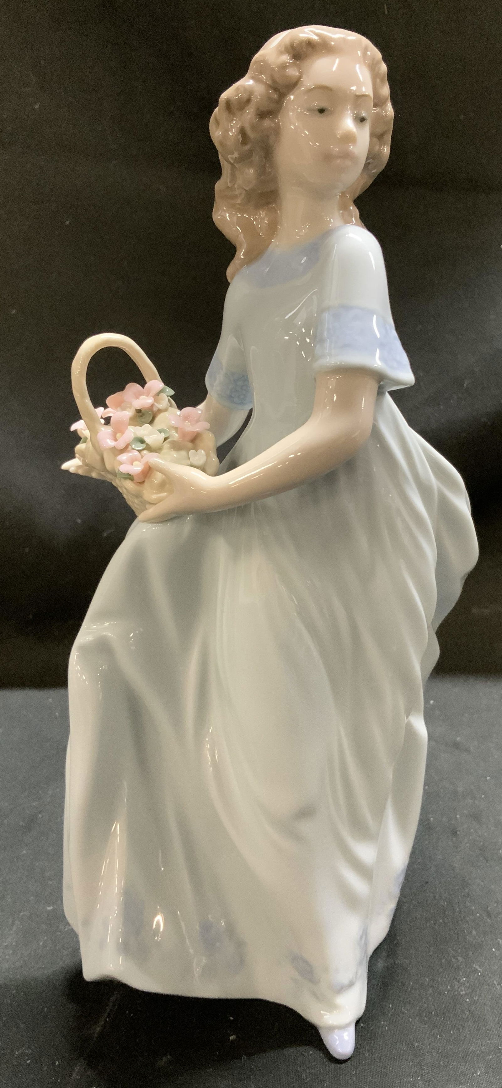 Lladro Spring Enchantment Porc Figurine SPAIN 1993: Figurine depicts a young woman with light brown hair, wearing a long, flowing, pale blue-and-white dress. She is holding a basket of pink and white flowers in her arms. Signed & marked on underside. R