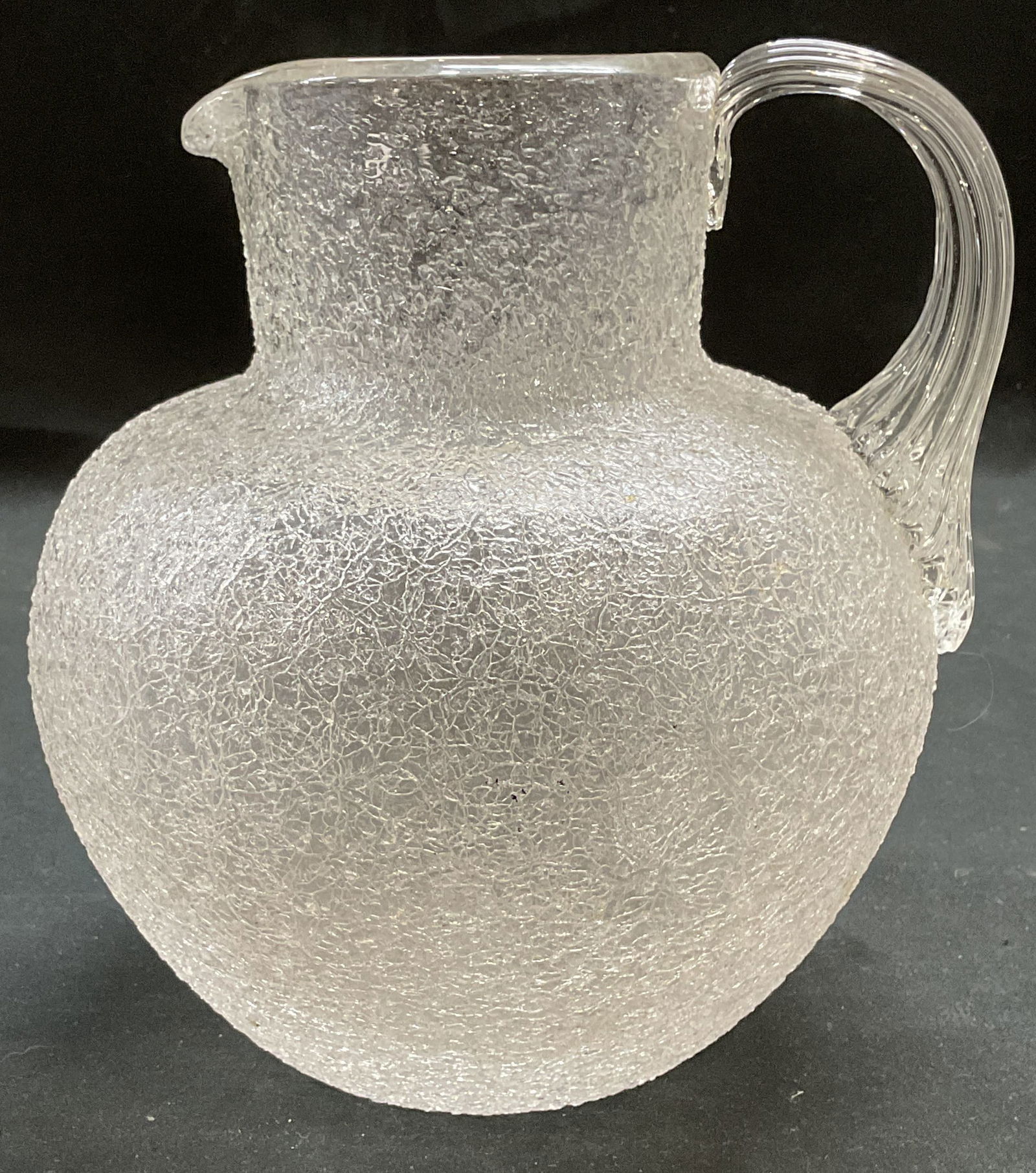 Clear Blown Crackle Art Glass Pitcher: Clear blown crackle art glass pitcher with applied handle. Measures approx 6 x 7 inches. Some wear consistent with exposure. Art glass pitcher, crackle glass pitcher, tableware, table accessories, hom