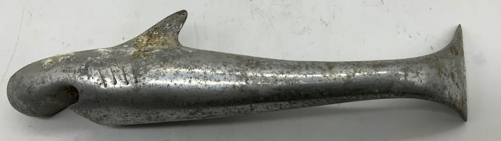 Vintage Shark Metal Bottle Opener: Opener is shaped like a shark, using its mouth to hook onto & remove caps. Piece is metal. Surface wear consistent to age, use & exposure. Measurements: length 7in x width 1.5in x height 1.4in. Vintag