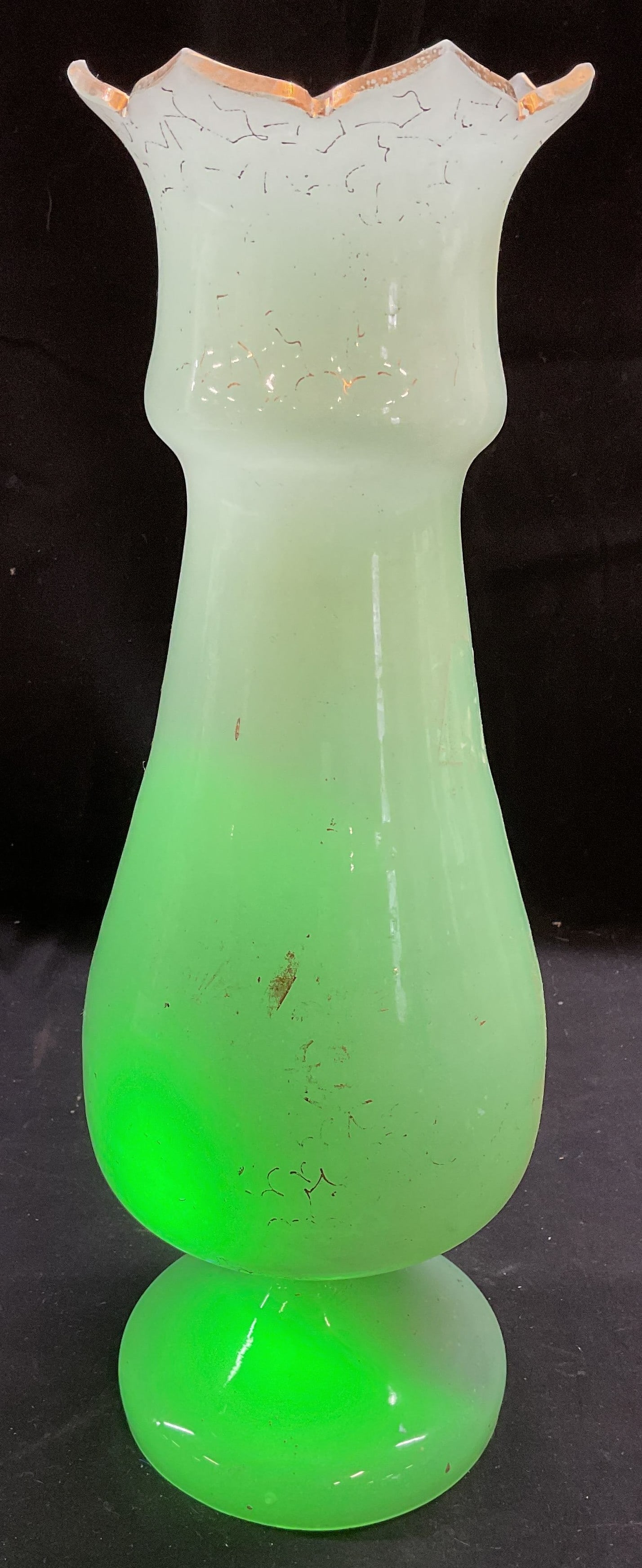 Vintage Jade Gilt Uranium Glass Vase: Vintage uranium blown glass vase. Jade green. Gilt decoration. Scalloped rim and pedestal base. Measures approx 4 x 12.25 inches. Wear including scratching, loss to paint, and chips observed. Uranium 