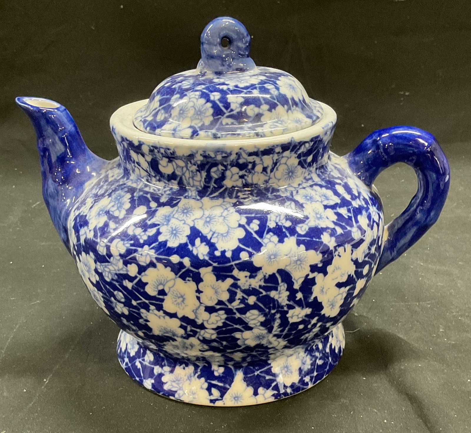 Blue & White Floral Porcelain Teapot: Porcelain teapot. Blue and white with floral pattern. Measures approx 9 x 6 x 7.5 inches. Some wear consistent with exposure. Porcelain teapot, floral teapot, blue and white teapot, tableware, table a
