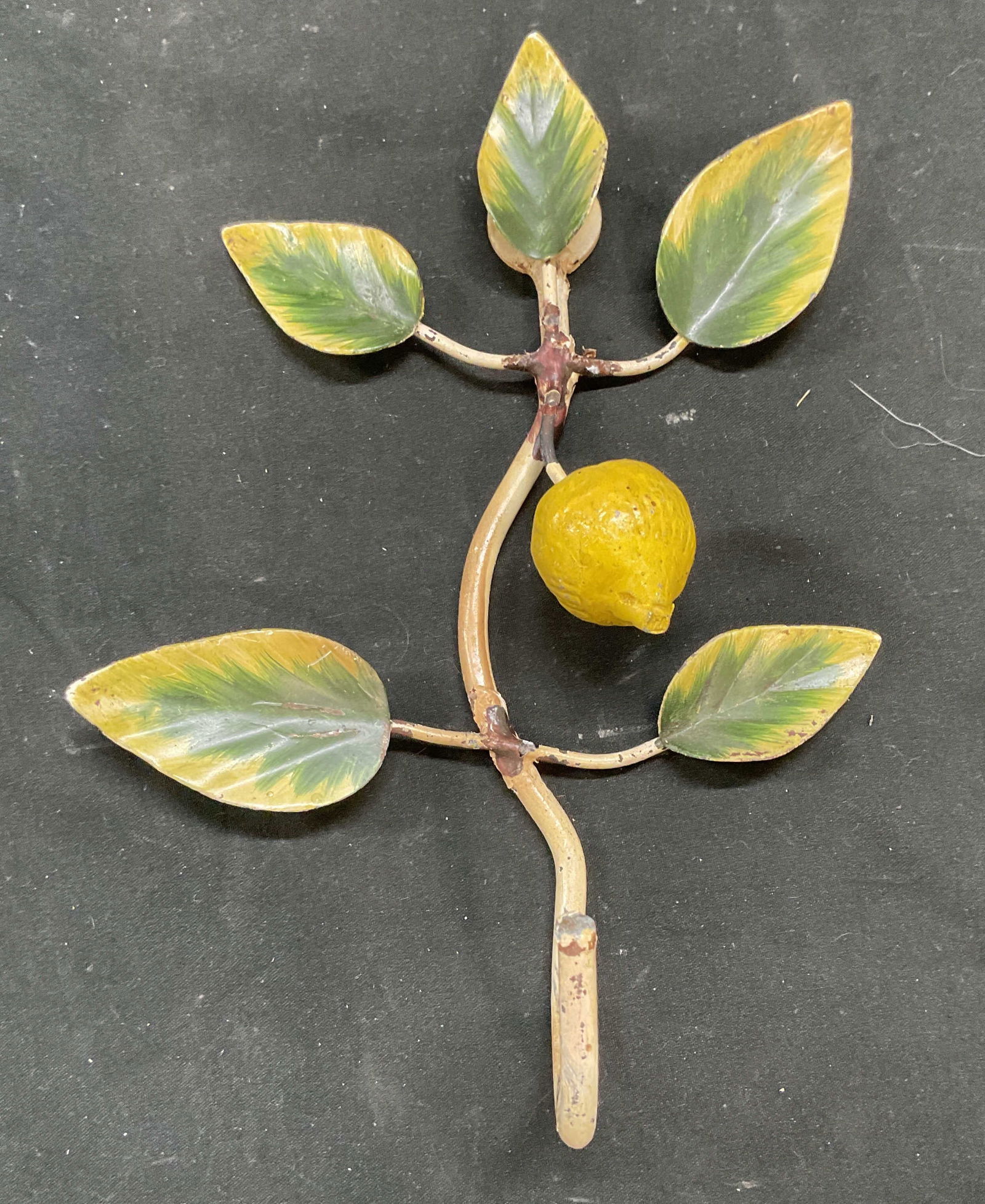 Vtg Enameled Metal Lemon Wall Hook: Vintage hand painted enameled metal lemon botanical plant wall hook. Measures approx 8 x 5.75 x 2 inches. Some loss to enamel and scratching. Wall hook, enamel wall hook, lemon wall hook, wall decor,