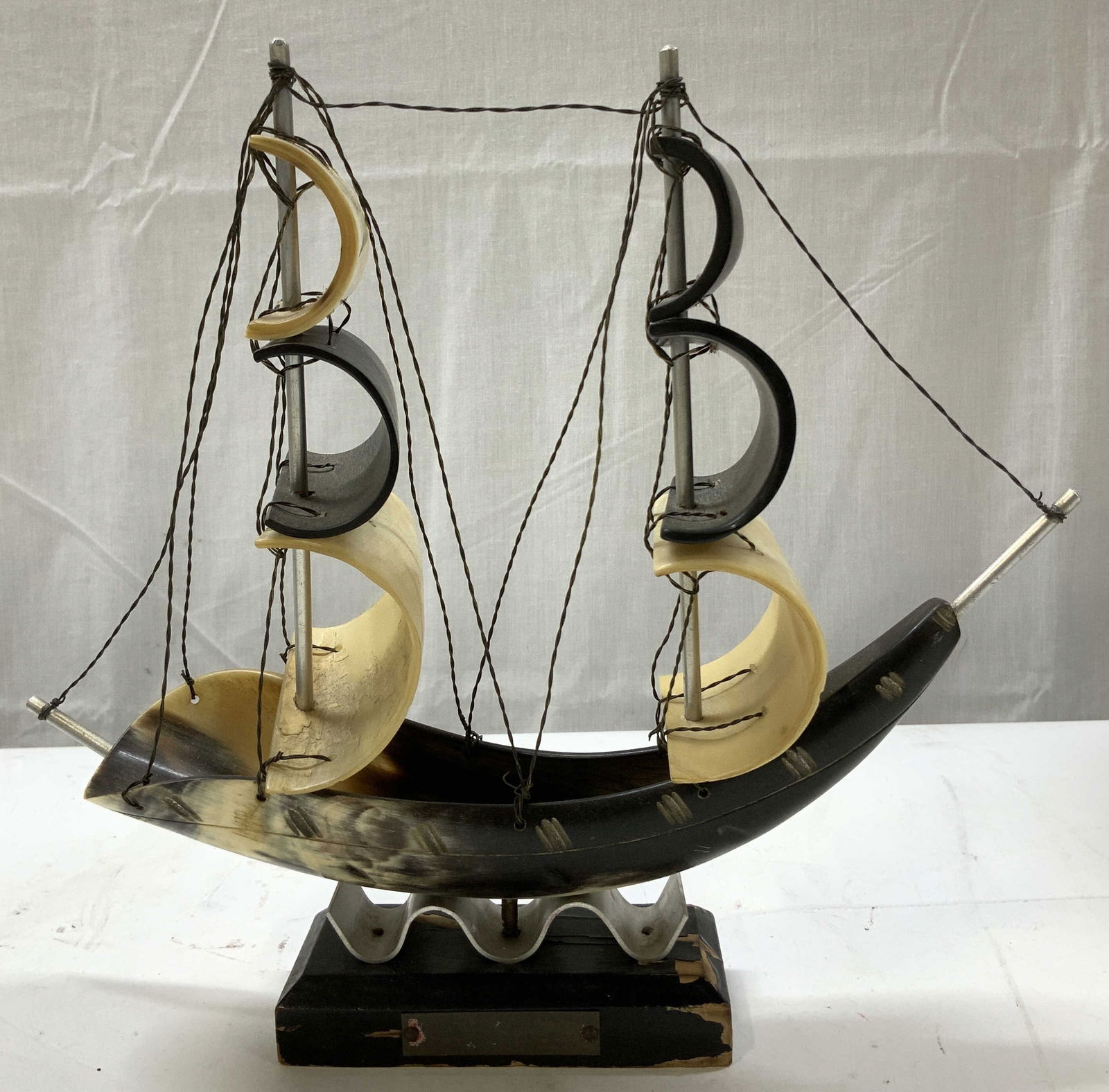 Vtg Hand Carved Horn Sailing Ship Model: Hand crafted sailing ship featuring a carved horn hull & curled horn sails. Cream & black tones. Ship is mounted on wooden base. Surface wear consistent to age, use & exposure. Measurements: length 10