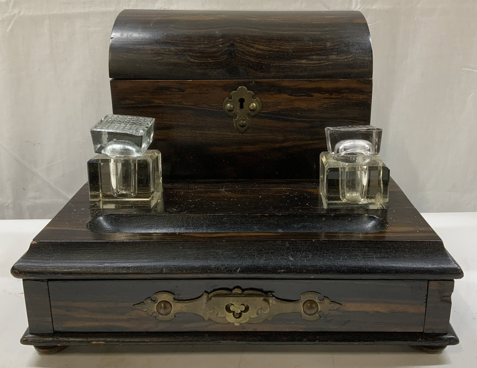 Antique Coromandel Wooden Desk Set: Piece is antique & features a dome-top stationary box w a hinged lid, a single drawer on the bottom & 2 cut-glass inkwells w lids. Piece is wooden. Surface wear consistent to age, use & exposure. Visi