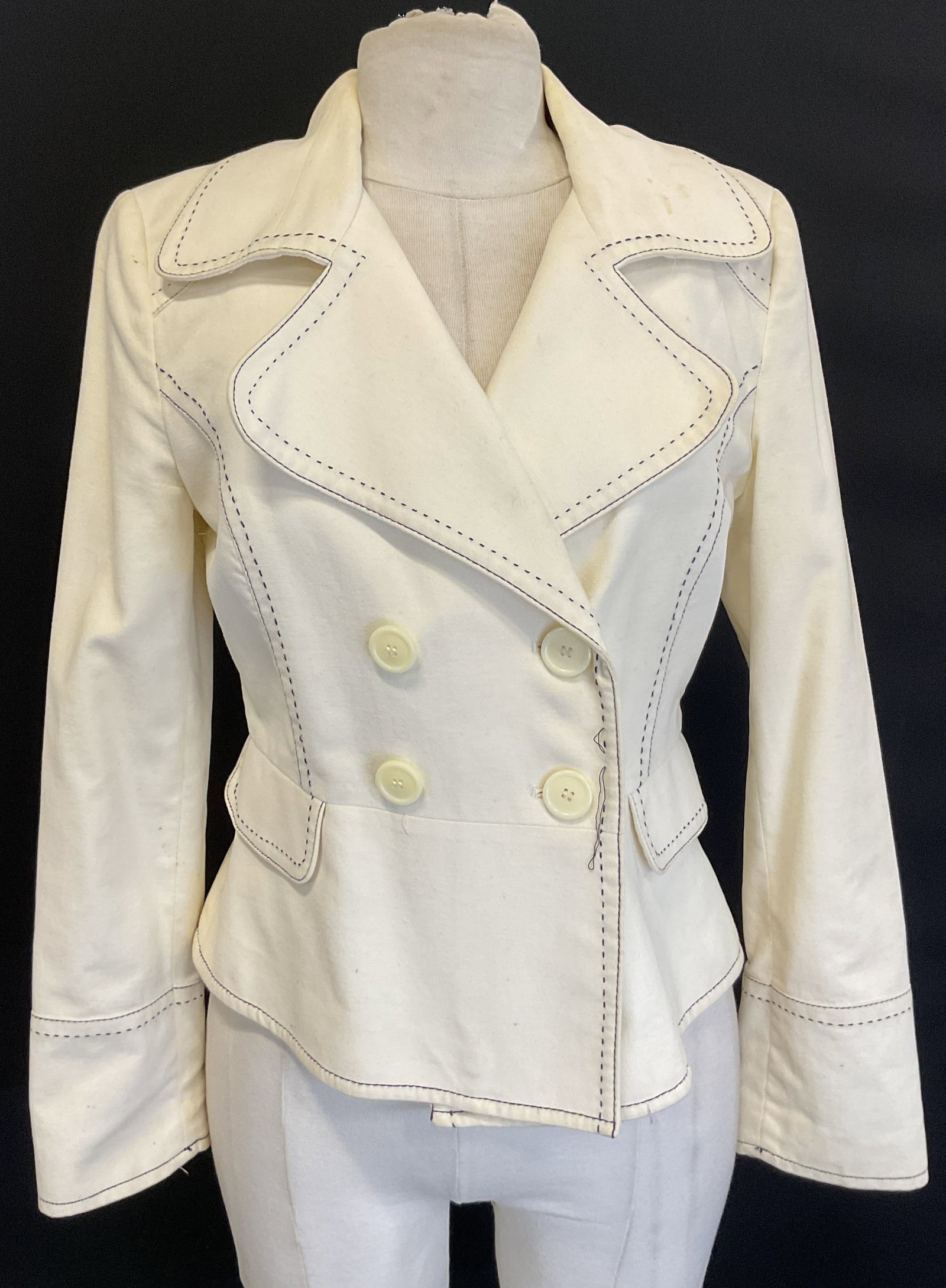 MNG White Contrast Stitch Jacket: MNG white jacket with black contrast stitching. Notch collar and front buttons. Size 8. Viscose and polyester blend. Wear to material including blemishes and lost to stitching. Property of 1980s known