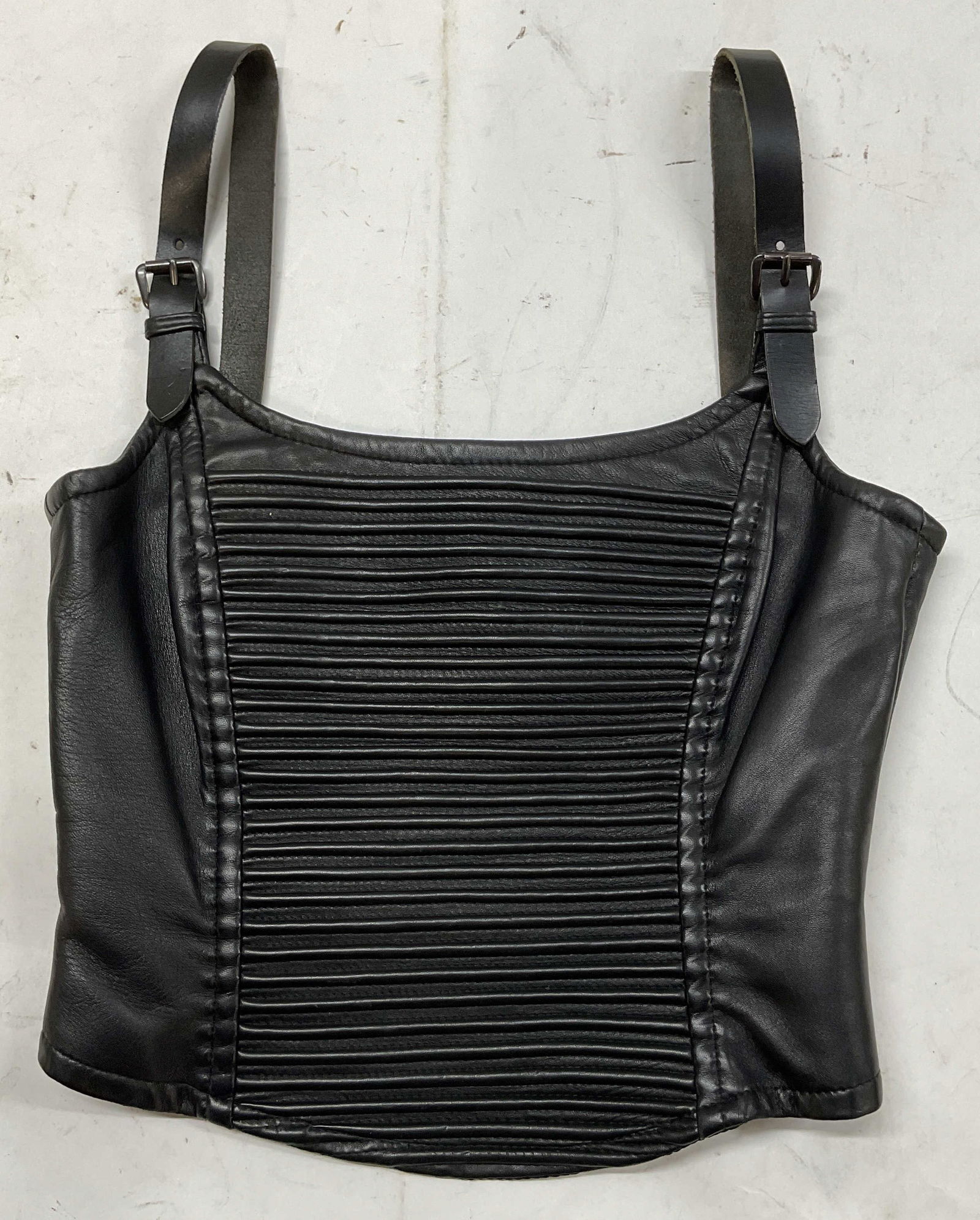Istvan Francer Black Leather Sleeveless Top Italy: Istvan Francer black leather sleeveless top. Made in Italy. Cropped fit. Size 40. Leather material. Polyester lining. Ribbed texture on chest. Buckled straps. Zipper on side of garment. Wear to leathe