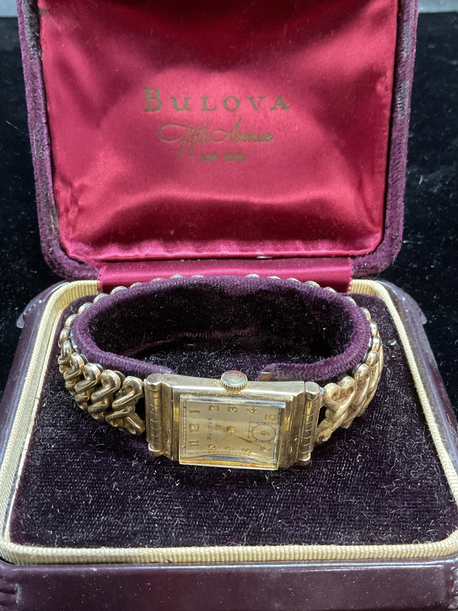 Vintage 1950s Bulova 10k Gold Filled Watch: Vintage 1950s Bulova 10k gold filled watch with bracelet band. Signed on dial. Case measures approx 1.25 x .75 inches. Band needs repair. Not tested. Some scratching and patina. Includes Bulova watch 