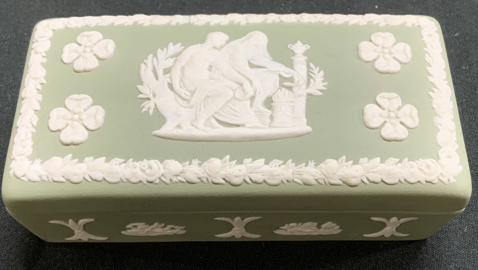 Wedgwood Green Jasperware Trinket Box ENGLAND: Rectangular trinket box comes w lid& features a central classic scene. Lid has floral motif border. Green matte toned. Signed & marked. Reads, WEDGWOOD. MADE IN ENGLAND. Surface wear consistent to age