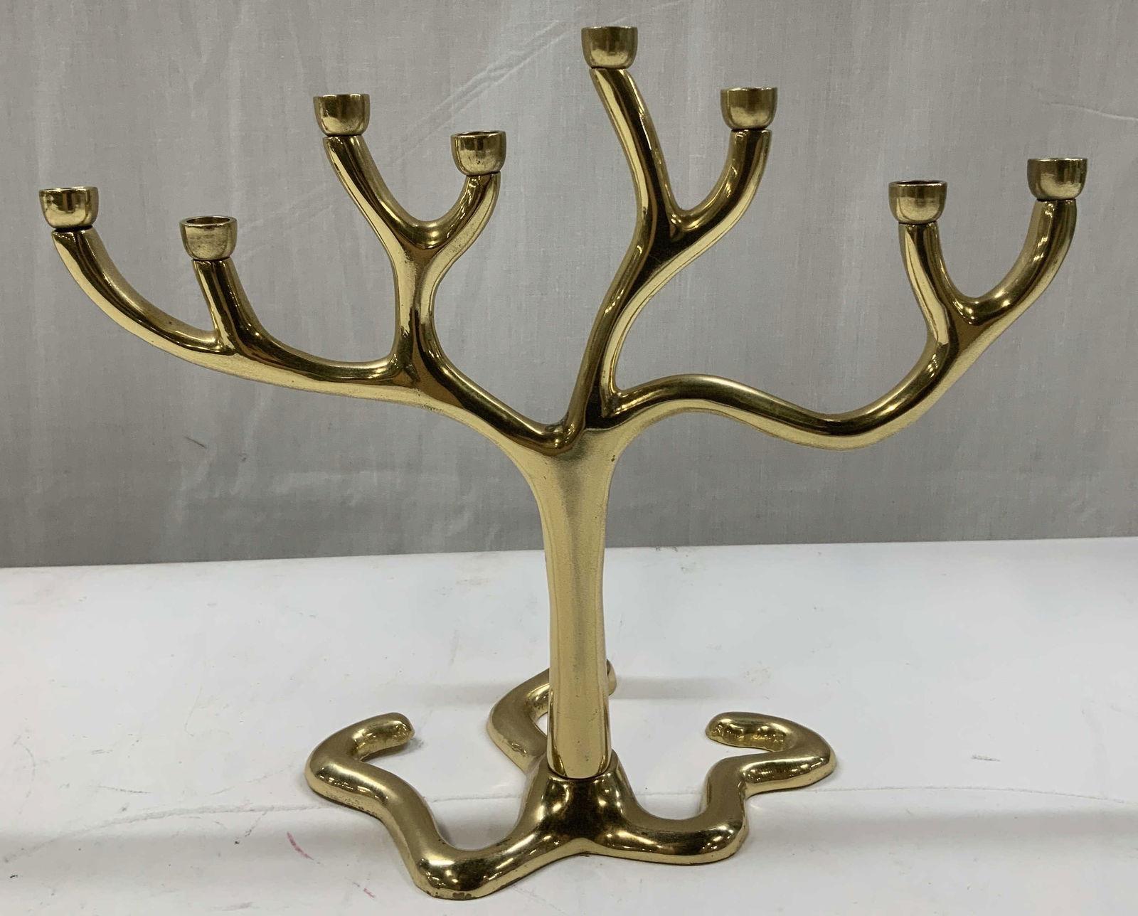 Payal Brass Plated Judaica Tree of Life Menorah: Menorah is brass plated & features a stylized tree form. Nine branching candle holders & a root like base. Signed & marked on underside. Reads, MADE IN INDIA. PAYAL. Surface wear consistent to age, us
