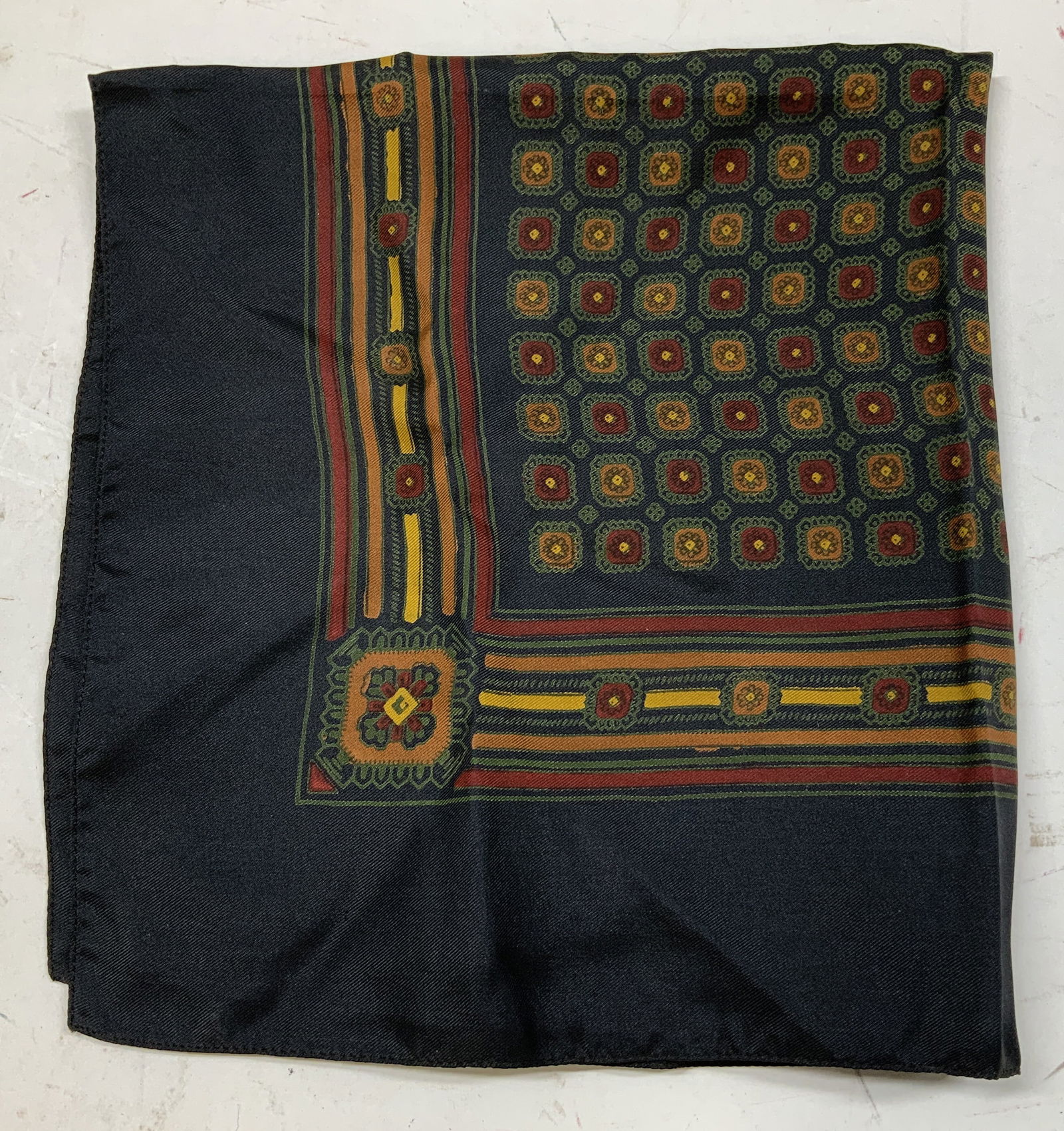 Vtg Hand Block Printed Geometric Handkerchief ENG: Handkerchief is silk material & features a black, gold, & red geometric floral design. Hand block printed. Signed & marked. Reads, MADE IN ENGLAND. surface wear consistent to age, use & exposure. Meas
