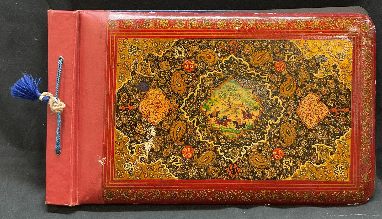 Hand Painted Wooden Photo Album: Hand painted wooden photo album. Front and back cover depict a Persian style scene. Hand painted polychromed designs with accented gold toned detailing. Features scene depicting figures, animals such 