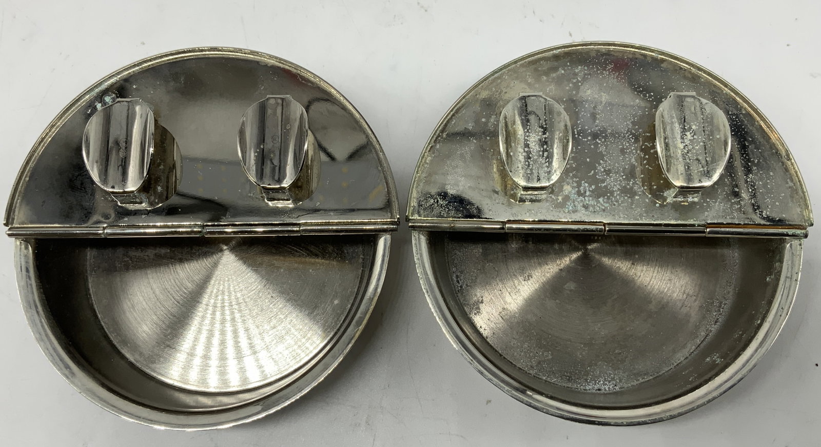 Set 2 Vntg Silver Plated Lidded Ashtrays: Ashtrays are silver plated & features a hinged lid. Interior has a deep well for ash. Visible markings on cigar rest. Surface wear consistent to age, use & exposure. Measurements: length 4in x width 4