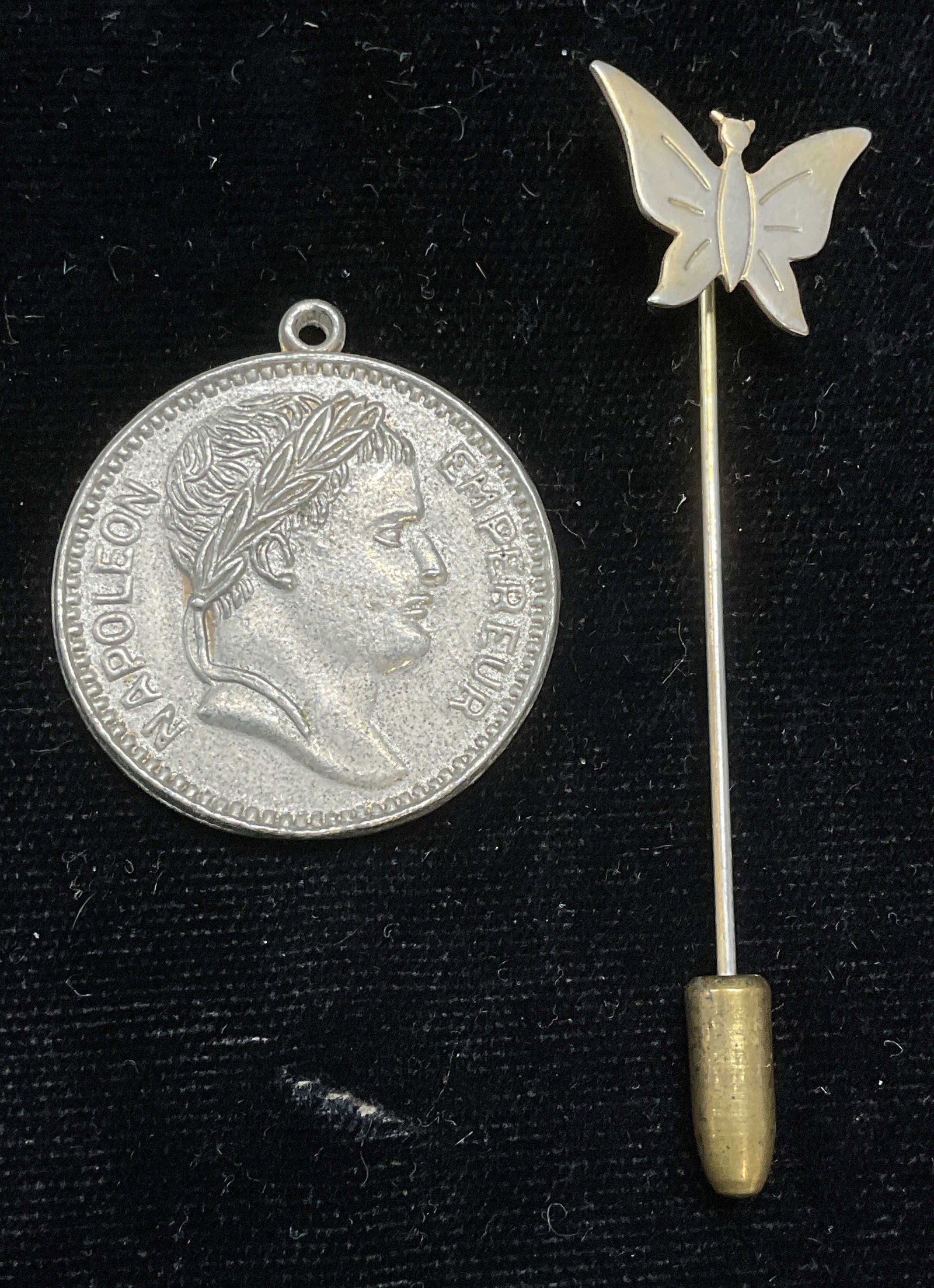 Lot 2 Silver Tn Butterfly Stick Pin & Coin Pendant: Lot of 2 jewelry pieces. Silver tone butterfly motif stick pin. Silver tone coin motif pendant. Pendant measures approx 1 inch wide. Some scratching. Jewelry, estate jewelry, costume jewelry, cocktail