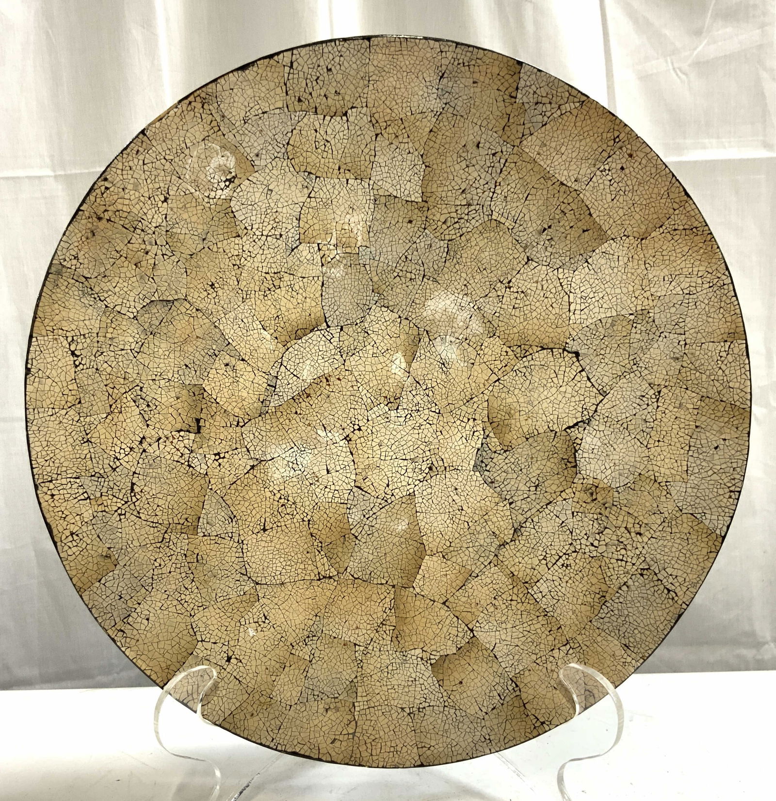 Crackled Lacquered Tabletop Centerpiece Bowl: Centerpiece bowl has black toned lacquered exterior. Interior is tan toned with crackled detail. Bowl has circular form. Piece measures approximately 15.75 inches diameter 2.25 inches tall. Bowl, lacq