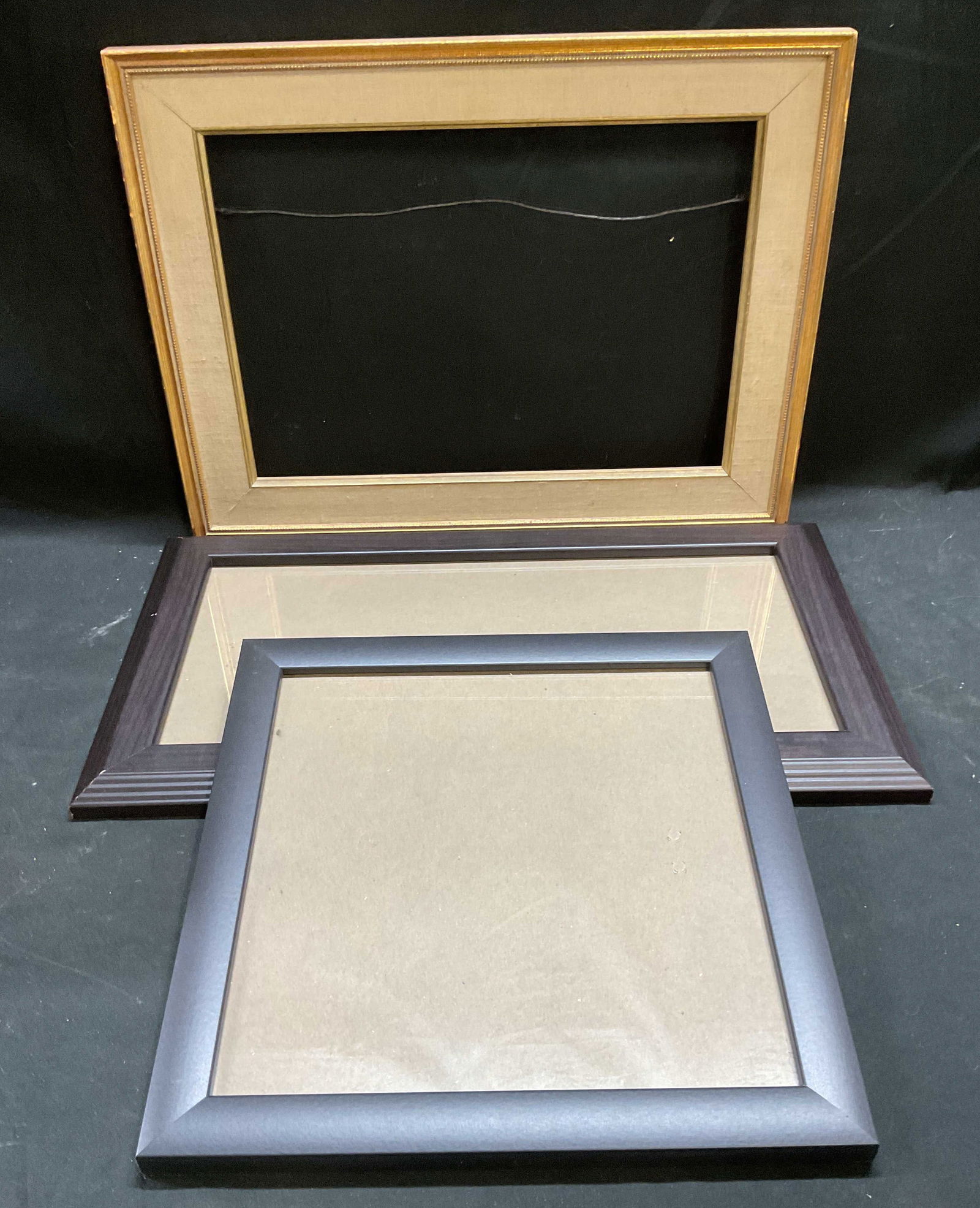 Lot 3 Gilt Brown Black Wood Art Picture Frames: Lot of 3 art/picture frames. Gilt wood with fabric mat, dark brown wood, and black wood. Gilt frame measures approx 12.5 x 16.5 inches, dark frame measures approx 10 x 18 inches, black frame measures