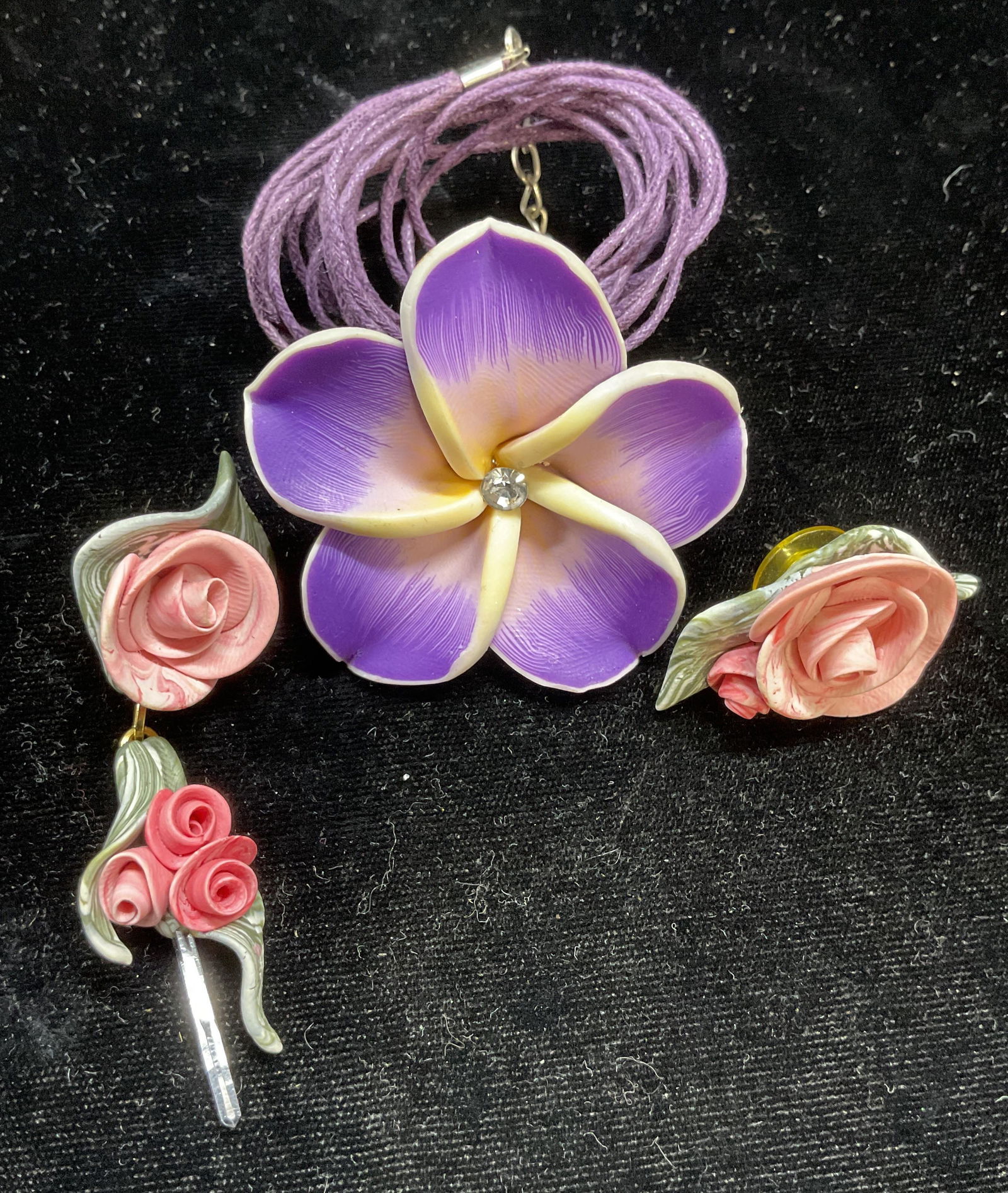 Lot 3 Flower Pendant Necklace, Earrings: Lot 3 jewelry pieces. Single handmade flower earrings. Larger measures approx 3 inches long. Purple flower Pendant necklace with purple cord. Drop length approx 9 inches. Some scratching. Jewelry, est