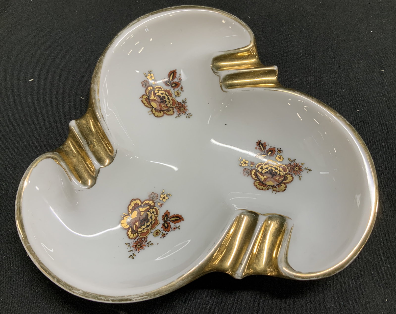 Rosenthal Floral Gilt Porcelain Ashtray GERMANY: Ashtray is porcelain w 6 raised indentations to hold cigarettes. Piece has floral details & a clove shape. Gold trim accents. Signed & marked on underside. Reads, ROSENTHAL. KRONACH-GERMANY. Surface w