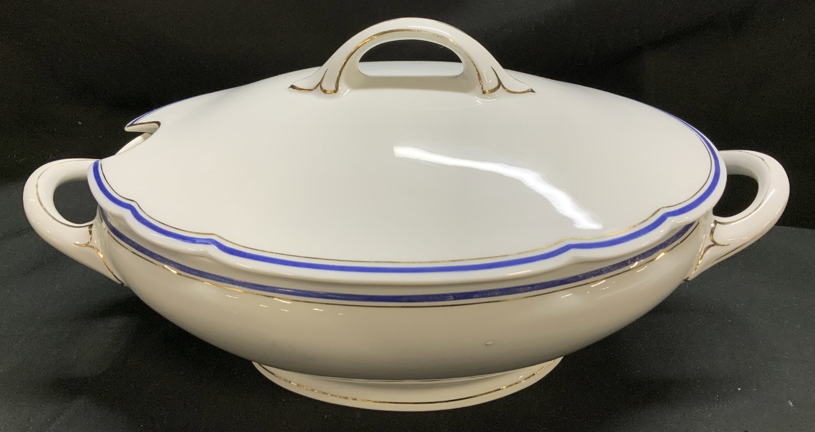 C.T. Blue & Gilt Striped Porcelain Tureen GERMANY: Tureen features a white base with blue bands and gilt lines along the edges & handles. Comes with lid. Piece is porcelain. Signed & marked on underside. Reads, C.T. ALTWASSER GERMANY. 301. Surface wea