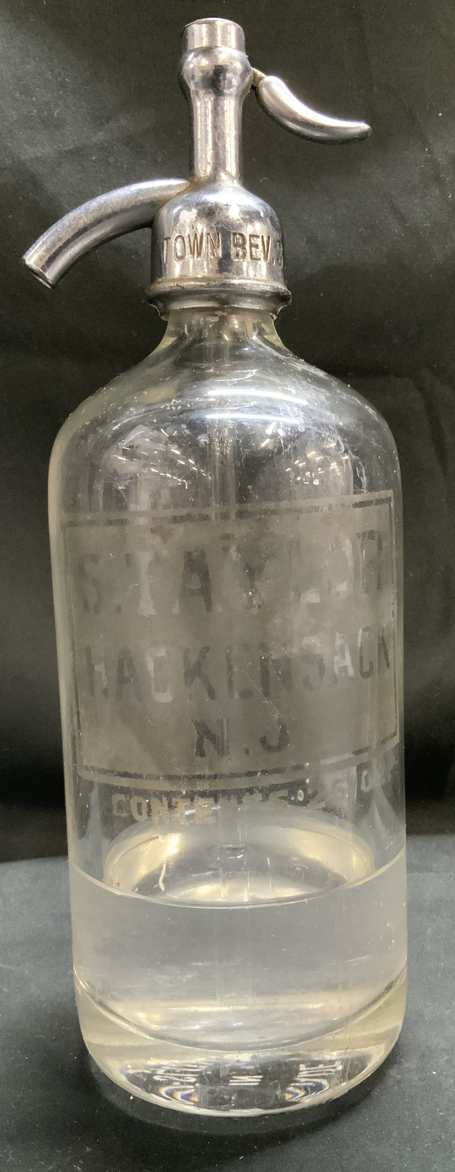 Vtg Town Bev S.V.N.Y. Etched Seltzer Bottle CZECH: Vintage clear glass seltzer bottle w a metal siphon top & an etched top that reads, TOWN BEV. S.V.N.Y. Body of seltzer reads, S.TAYLOR HACKENSACK N.J. CONTENTS 2602. Contains liquid. Surface wear cons