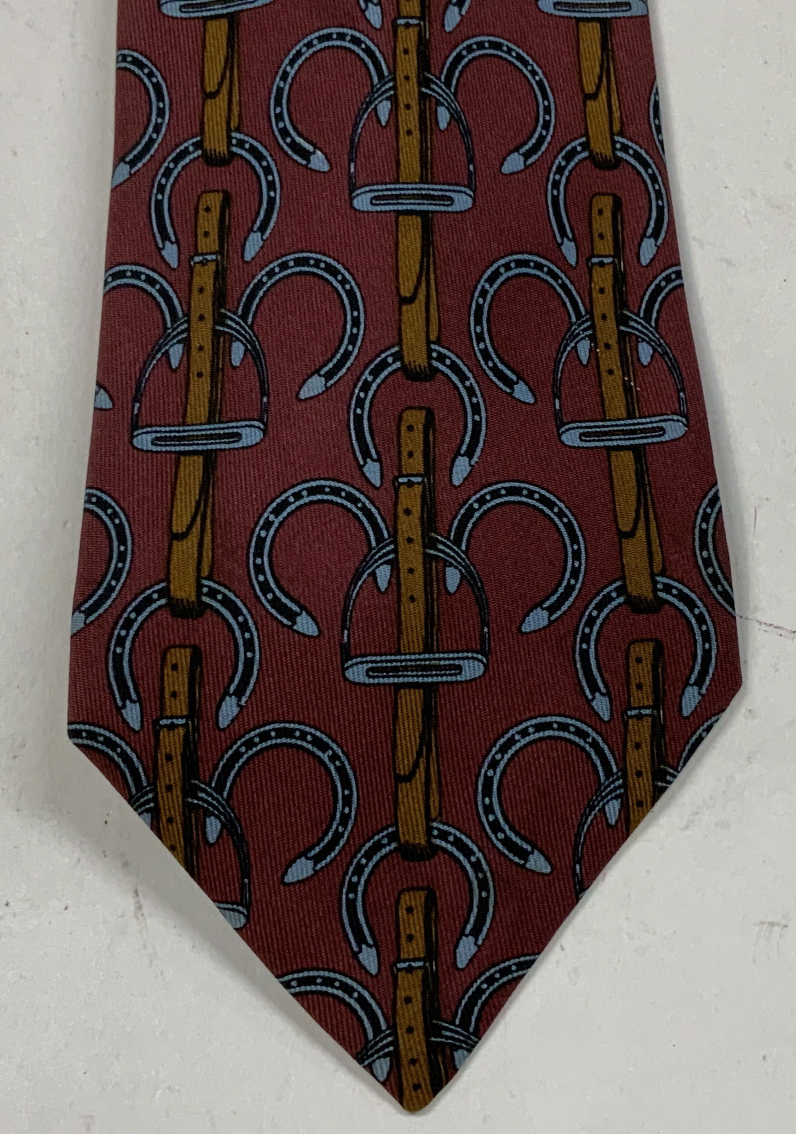Hermes Equestrian Silk Necktie FRANCE: Necktie is 100% silk & features an equestrian pattern of stirrups & horseshoes. Signed & marked. Reads, HERMES. MADE IN FRANCE. 100% Silk. Surface wear consistent to age, use & exposure. Measurements: