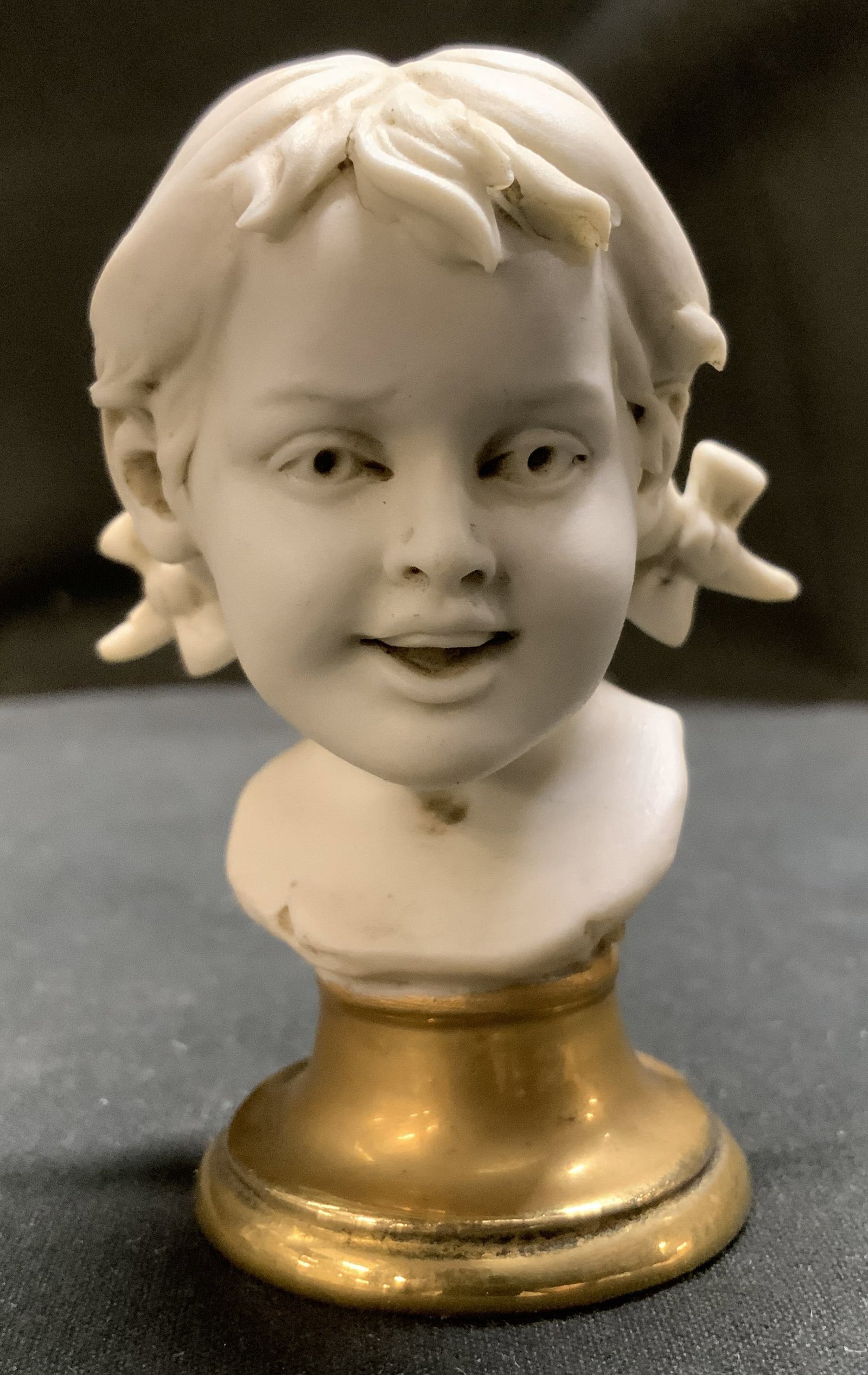 Vntg Friade Benacchio Porcelain Girl Bust: Girl bust is made of white porcelain & features a gold-toned base. Intricate & textured details. Bow details in hair. Backside of bust reads, BENACCHIO. Surface wear consistent to age, use & exposure.