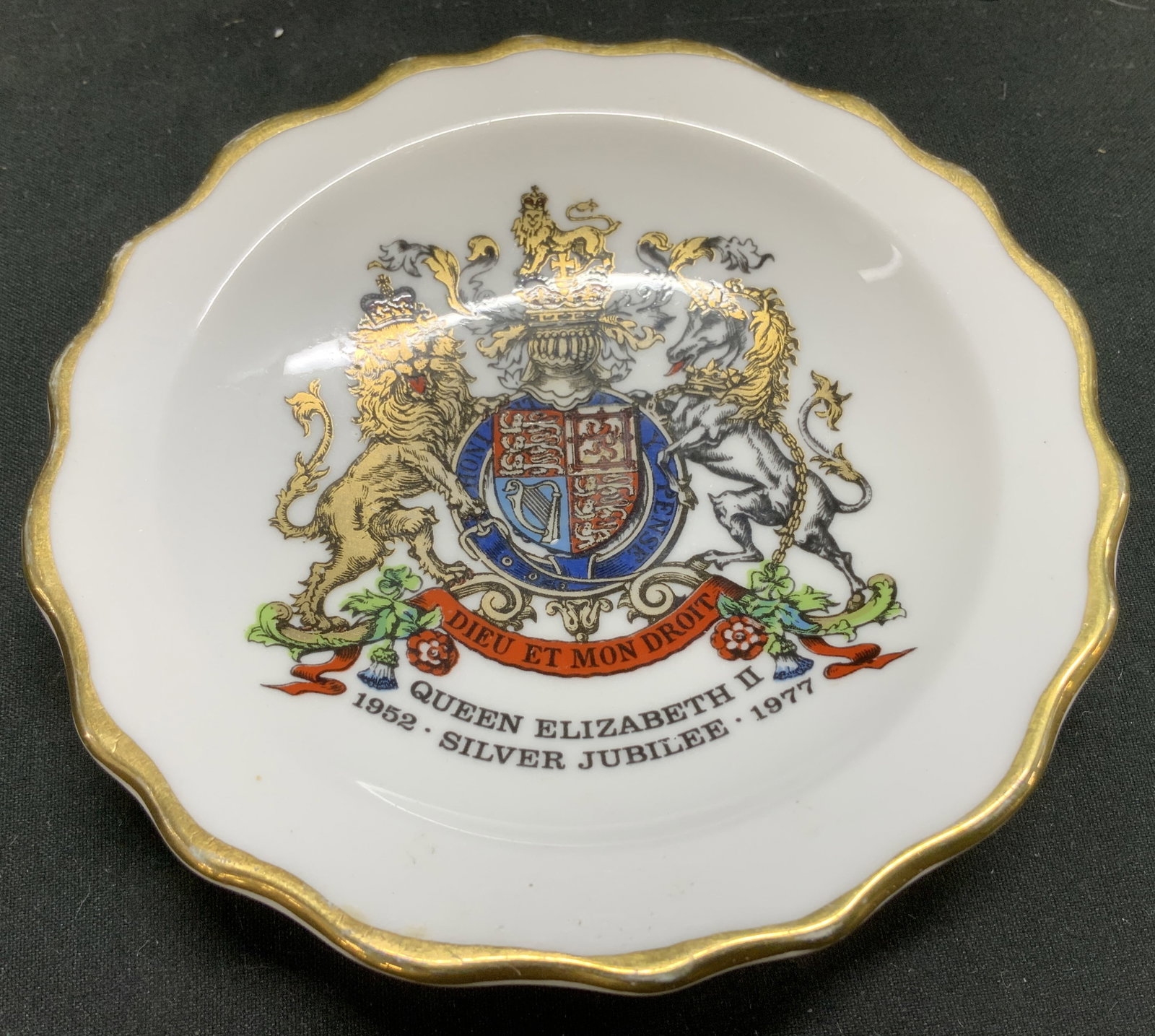Royal Stafford Queen Elizabeth II Trnkt Dish ENG: Trinket dish commemorates the 25th anniversary of Queen Elizabeth IIs accession to the throne, which occurred in 1977. It features the Royal coat of arms and the inscription DIEU ET MON DROIT, along w