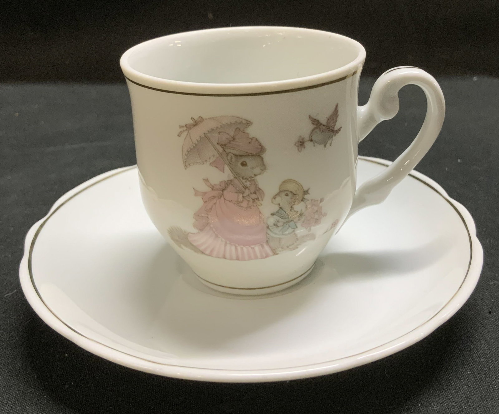 Tiny Talk Mouse Porcelain Teacup & Saucer BRAZIL: Teacup & saucer are genuine porcelain. Teacup features an illustration of 1 mouse in a dress & 1 mouse in a sailors outfit. Saucer has a scalloped edge. Signed & marked on underside. Reads, TINY TALK 