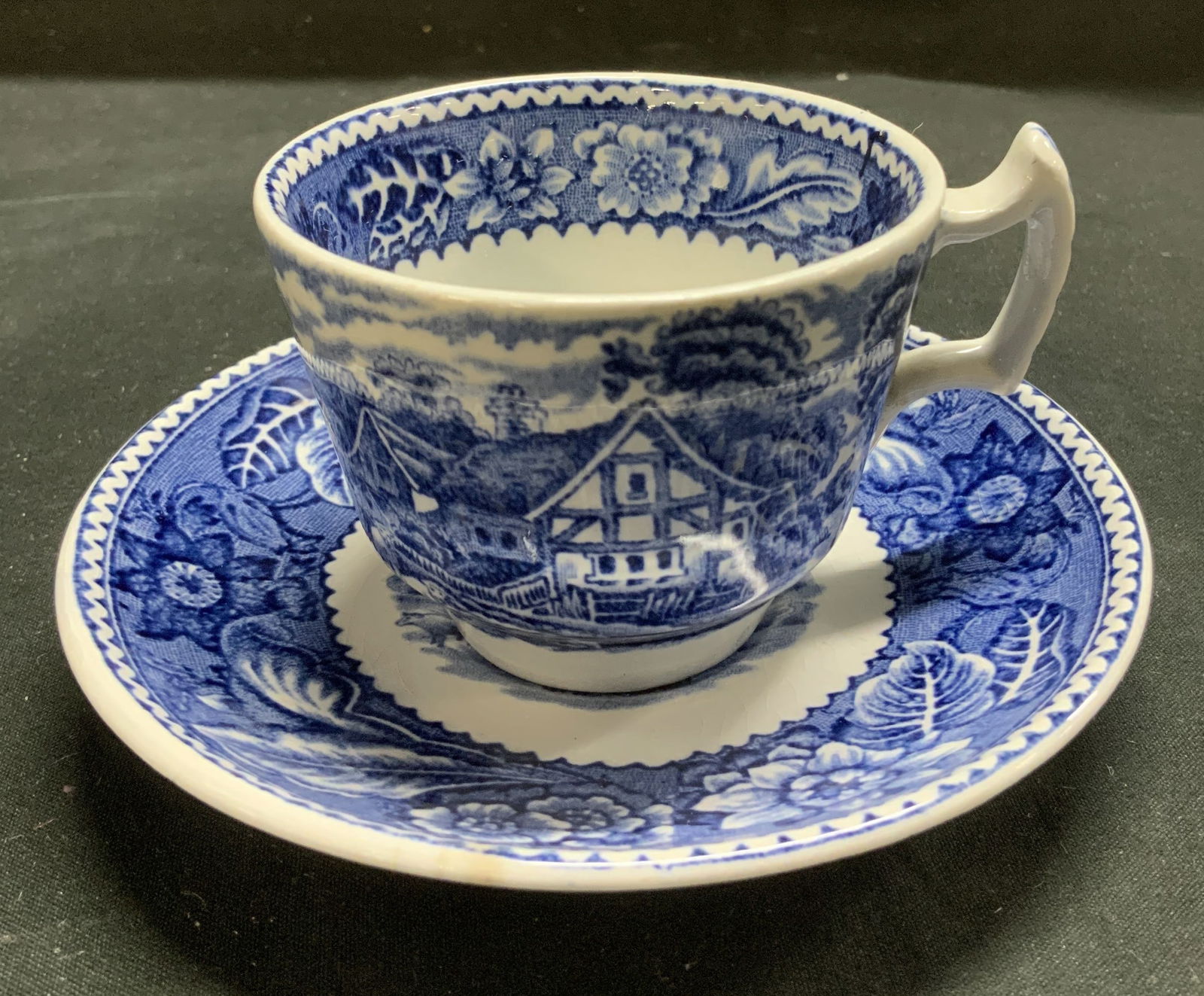 Wood & Sons Woodland Teacup & Saucer ENG: Teacup & saucer are ironstone/ceramic material. Feature a blue w white transferware design. English scenery in the center & floral borders. Signed & marked on underside. Reads, WOODLAND MOSES 1751. WO