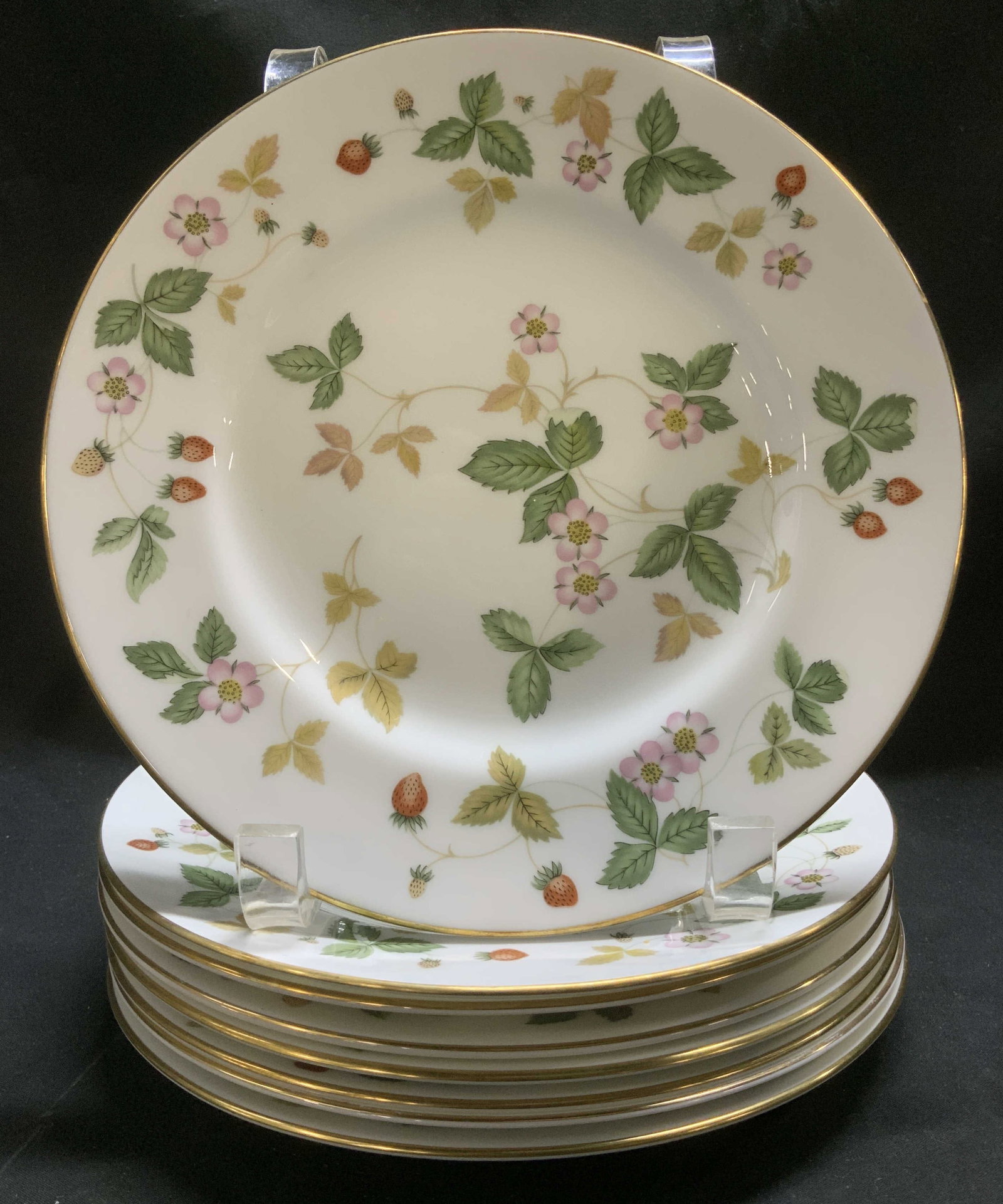 Set 8 Wedgwood Wild Strawberry Plates ENGLAND: Plates are bone china material & feature hand-decorated strawberry w leaf patterns. Gilt trim. Signed & marked on underside. Reads, WEDGWOOD. BONE CHINA. MADE IN ENGLAND. WILD STRAWBERRY. Surface wear